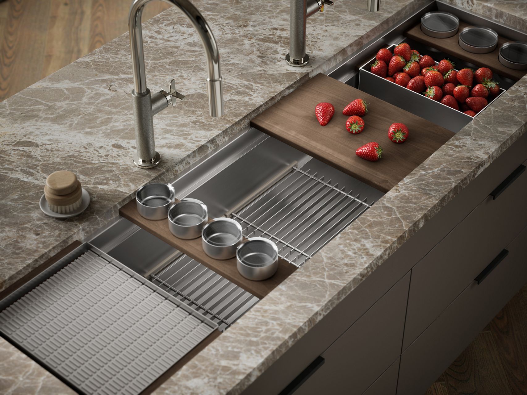 Stainless steel kitchen workstation sink with integrated accessories, including a sliding cutting board and colander, set in a stone countertop.