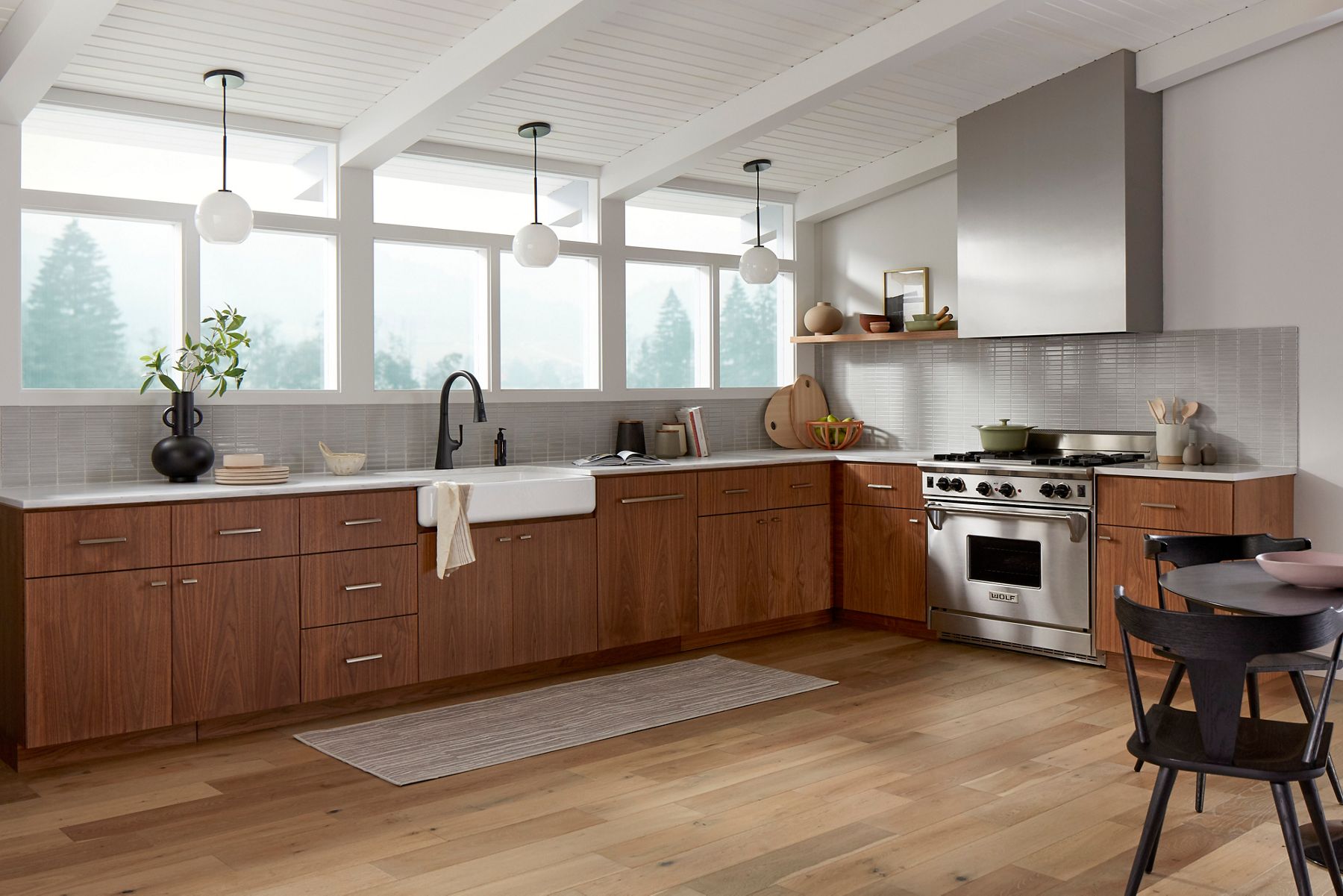 A kitchen with matte black faucets and accents and stainless steel cabinet hardware and appliances.