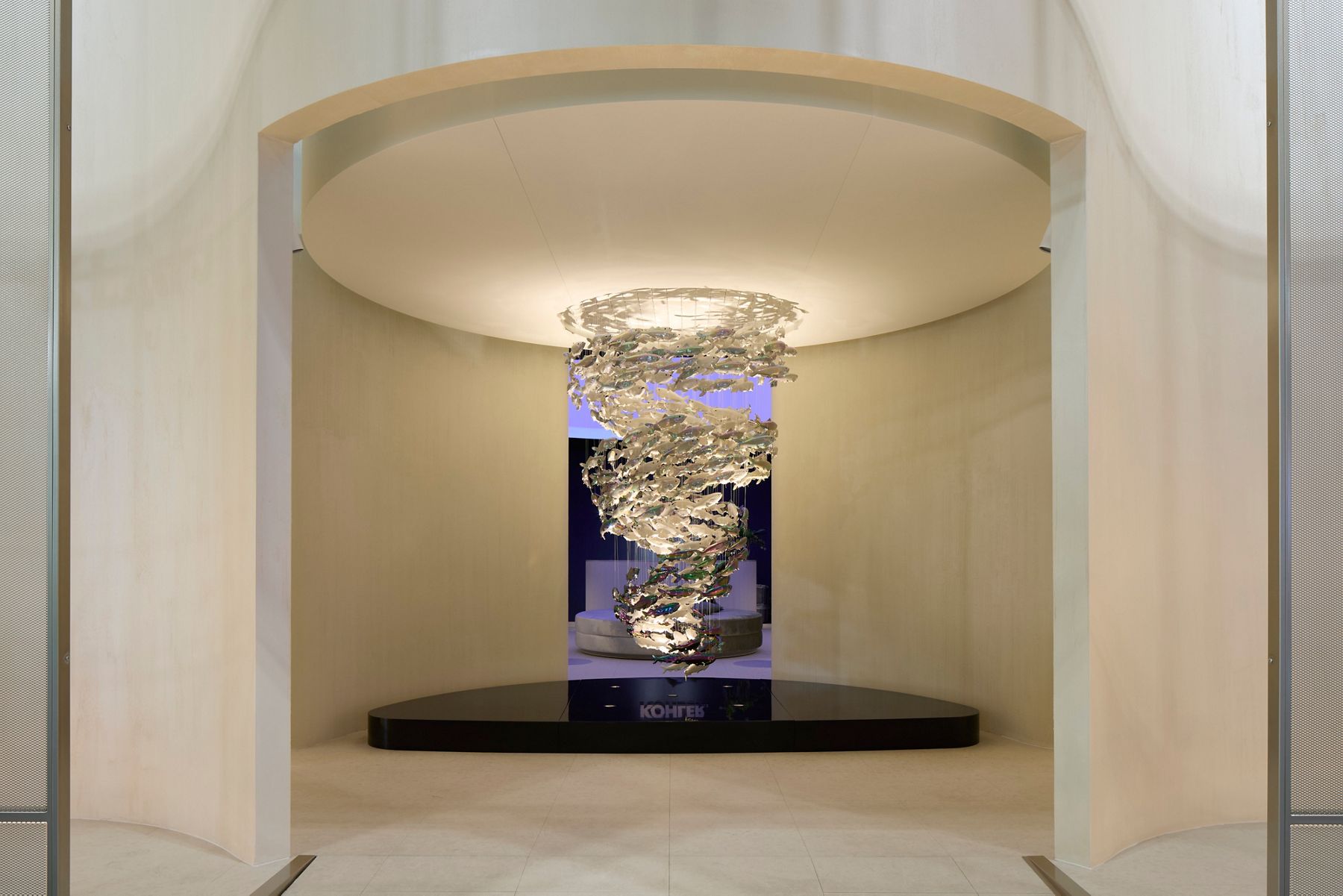 Artistic wall tapestry displayed in a modern arched gallery space with warm lighting.