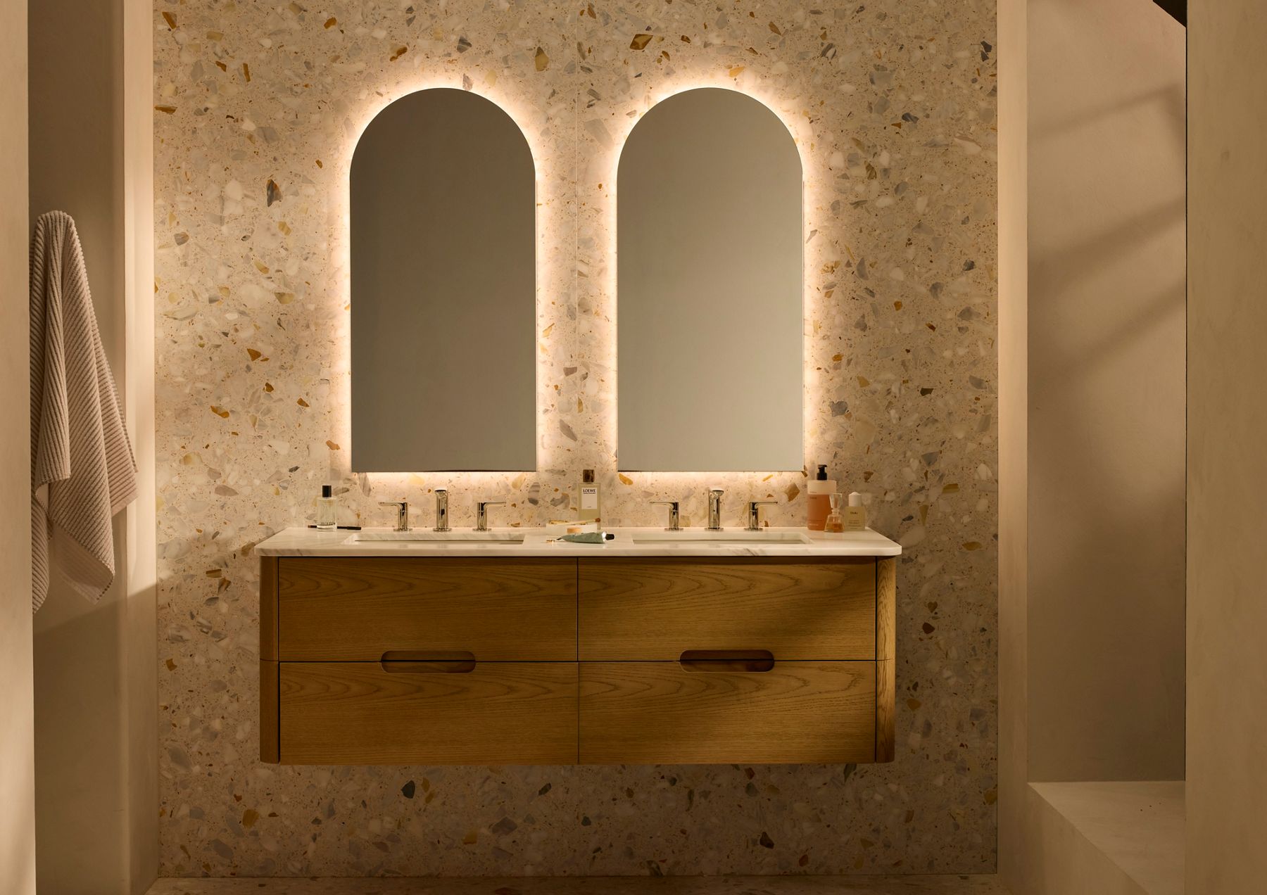 Minimalist white bathroom with floating shelves and wall-mounted black fixtures.