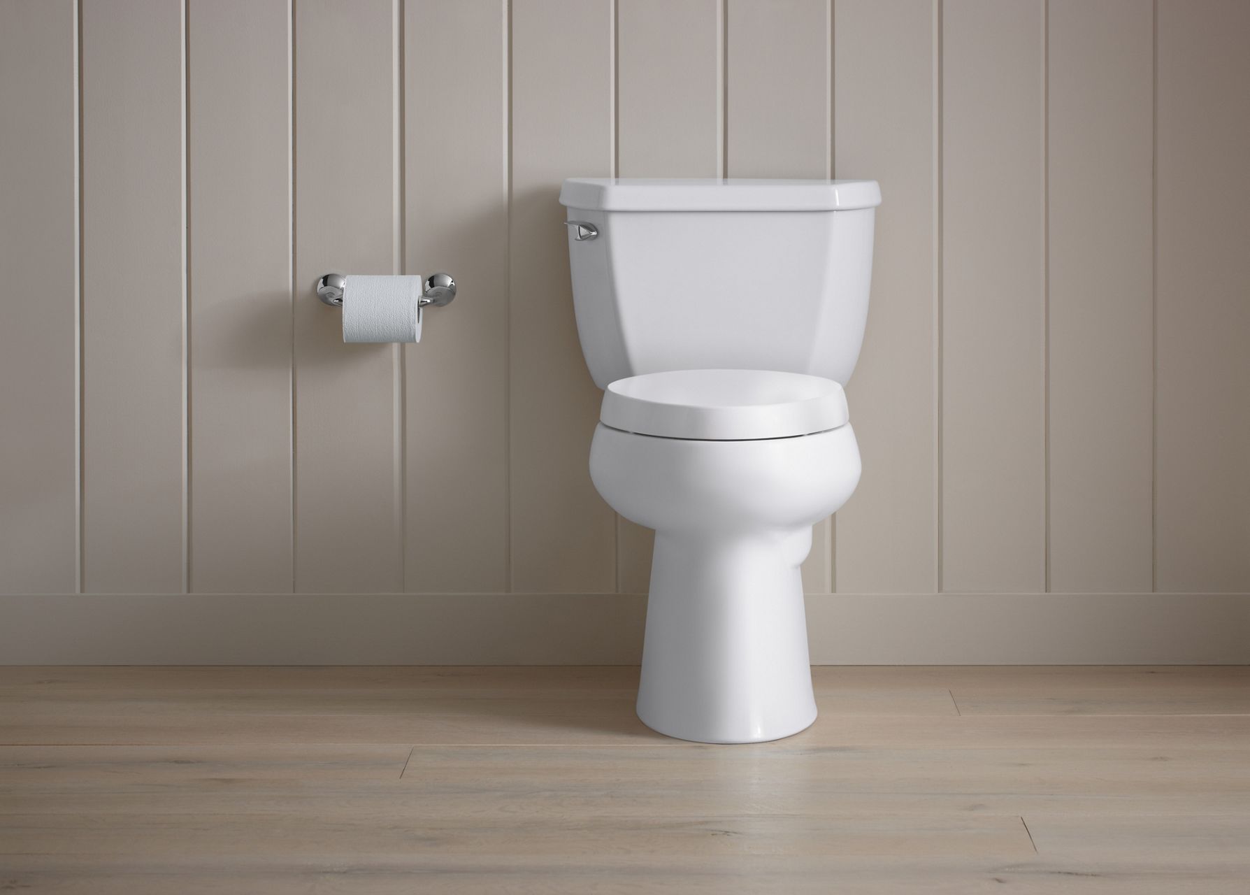 White KOHLER Highline Comfort-Height toilet against a white shiplap wall.