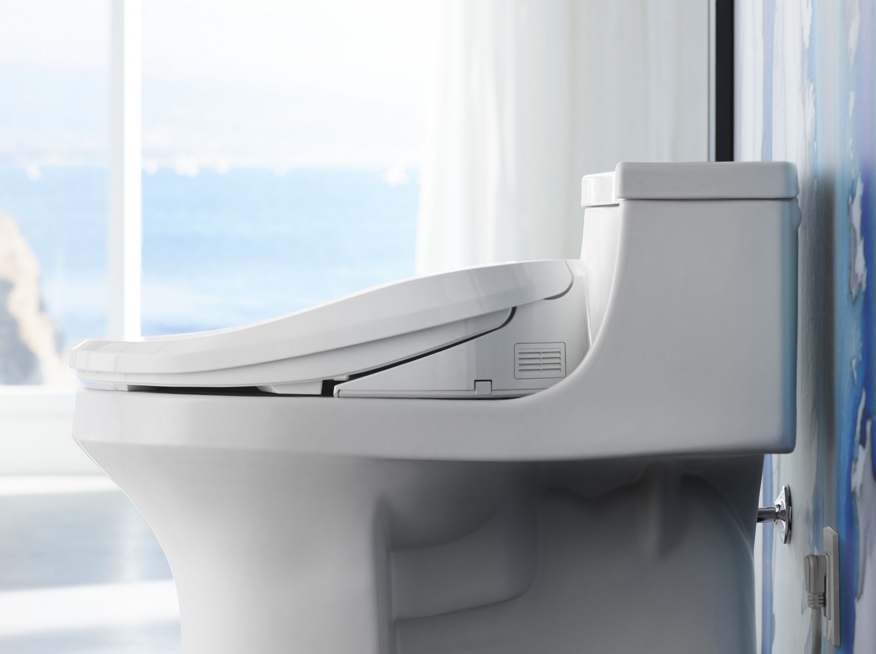 Profile view of a white KOHLER Sans Souci toilet with C3-155 cleansing toilet seat.