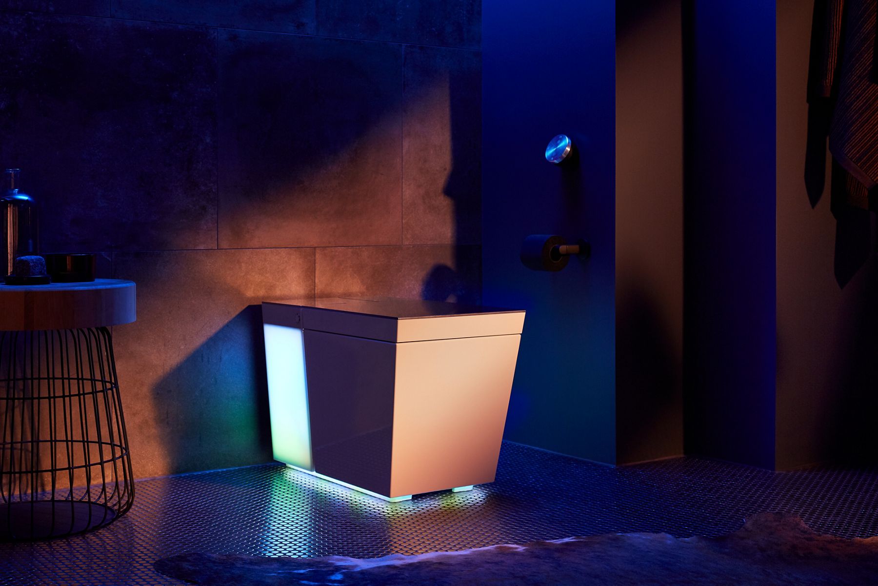 Kohler's Numi 2.0 Smart Toilet showing off its glowing UV light self cleaning function situated inside a modern bathroom.