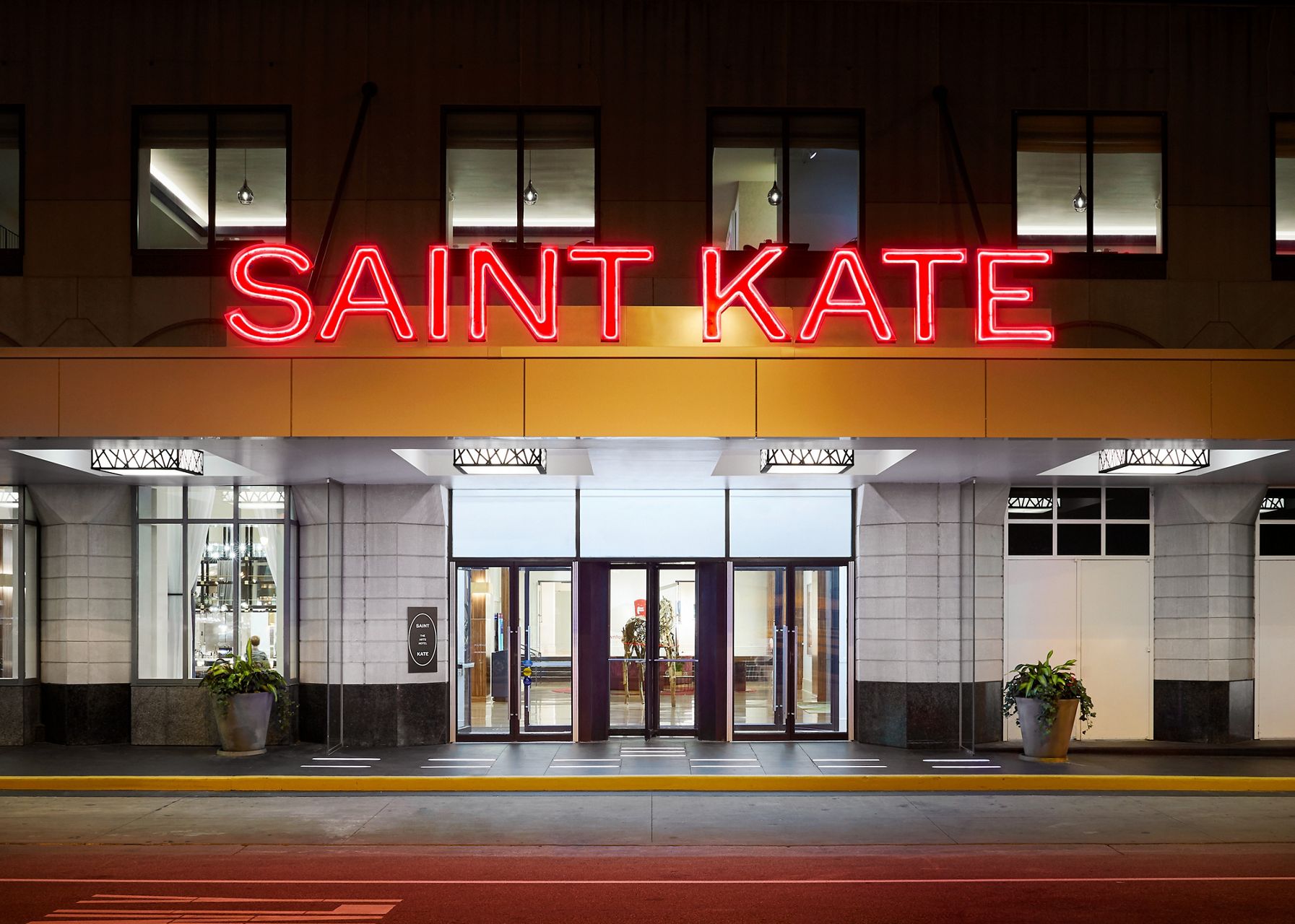 Evening view of the illuminated main entrance to the Saint Kate hotel.
