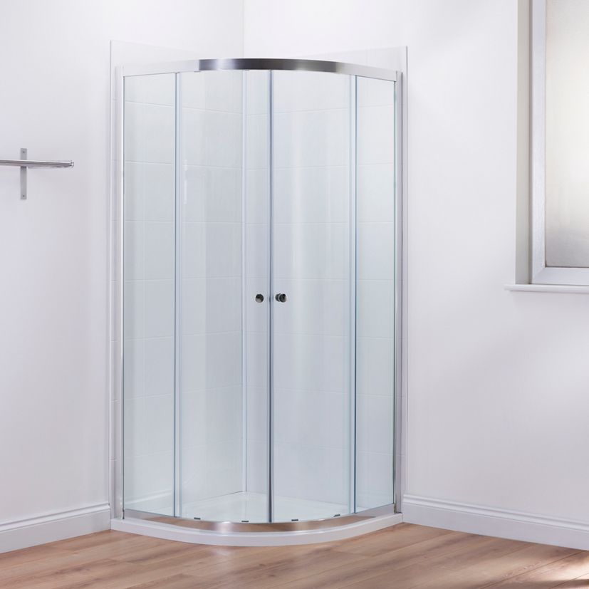 A Mira Elevate quadrant shower enclosure in a white walled, wood floored bathroom.