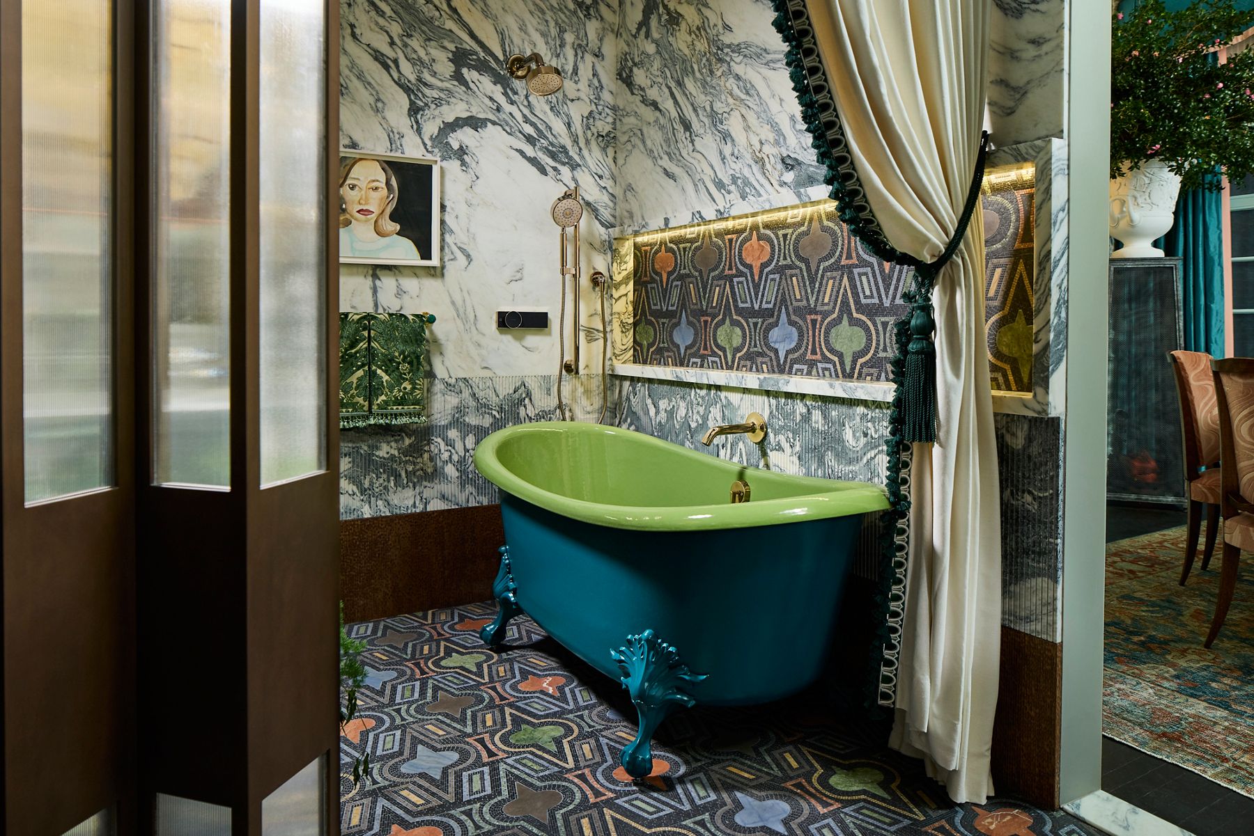 Une salle de bain de style rétro avec une baignoire verte, des murs carrelés à motifs et un rideau partiellement tiré.