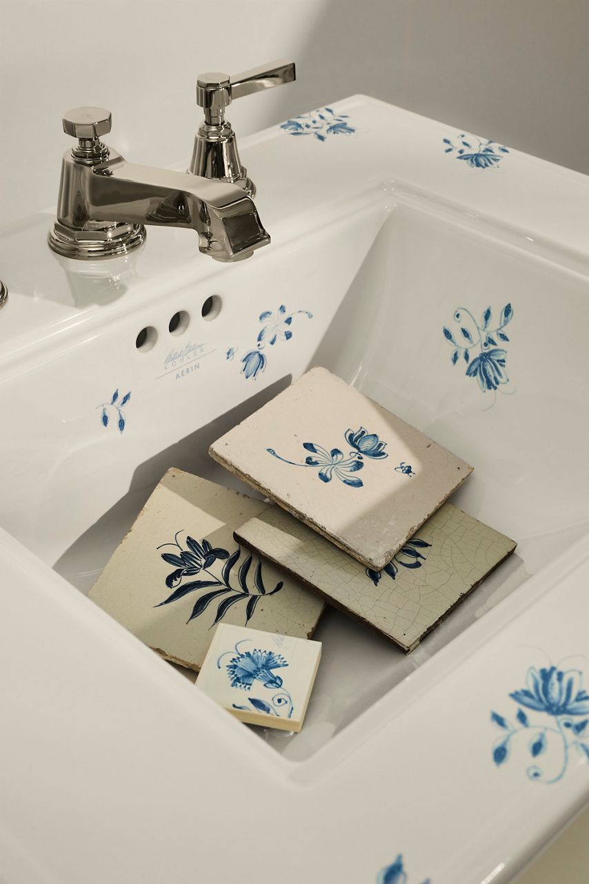 AERIN Memoirs sink in white with blue floral detailing, styled with coordinating blue-and-white decorative tiles and polished faucet.