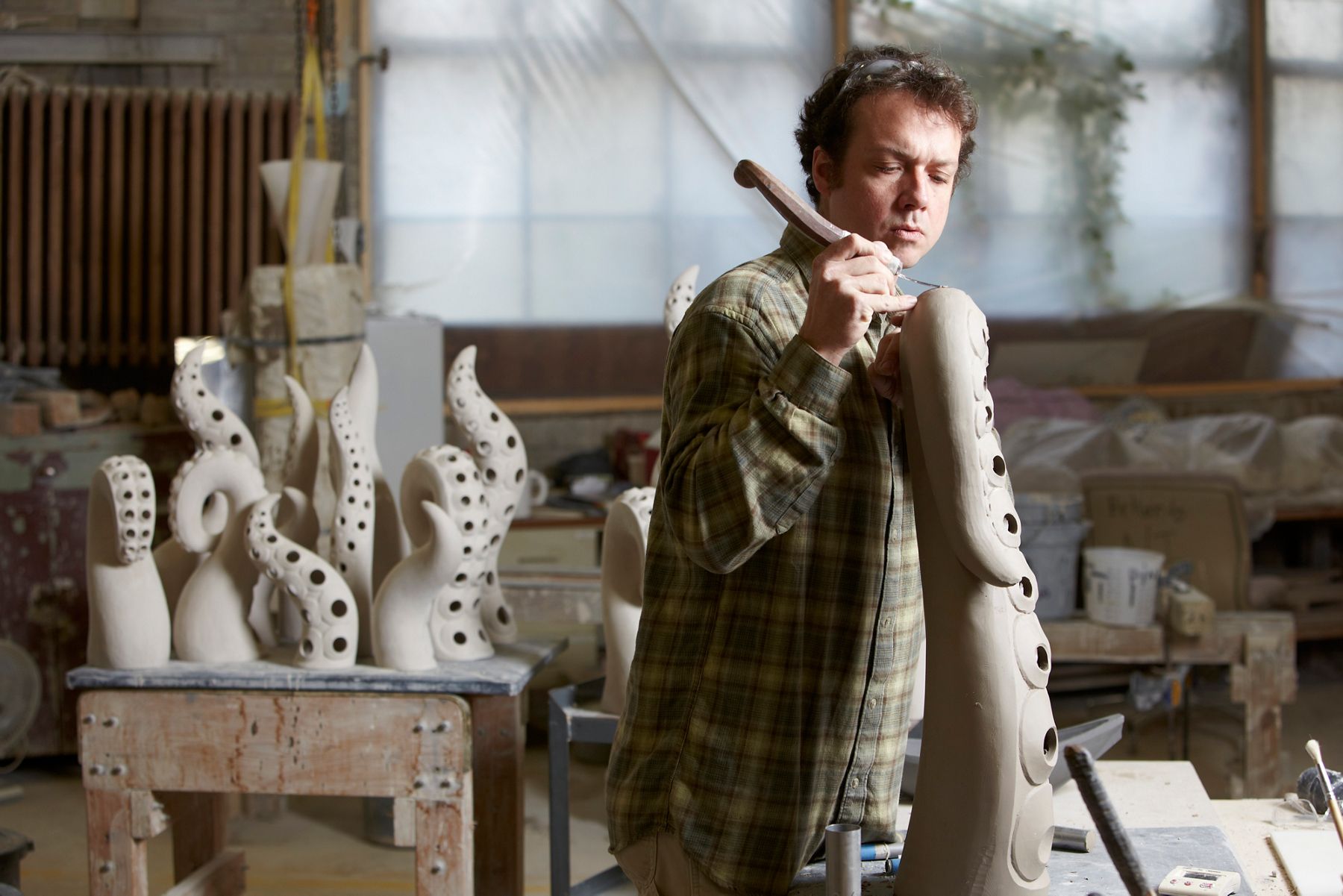 Artist sculpting organic ceramic forms in a workshop, part of Kohler’s Arts/Industry program exploring creativity and design collaboration.