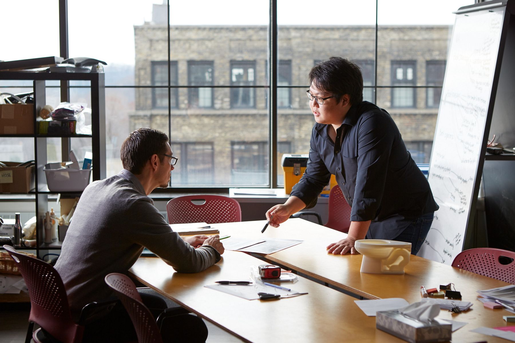 Two people collaborating in an office setting at a table.