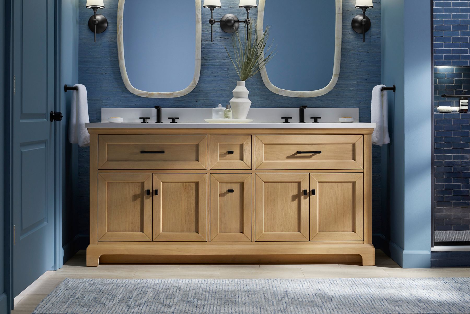 Charlemont vanity in an airy blue bathroom with black accents and fixtures.