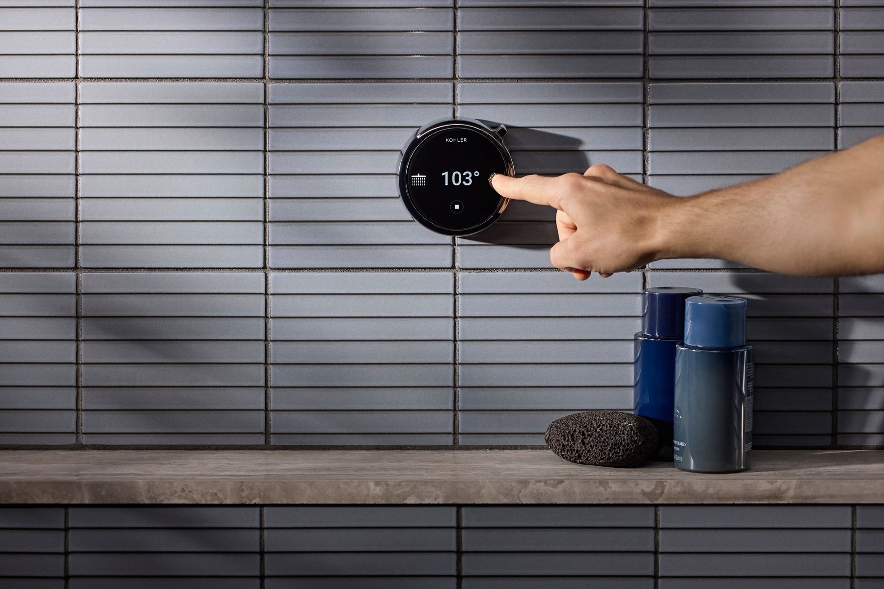 Man adjusting the digital controls  attached to the Anthem® Duo smart shower.