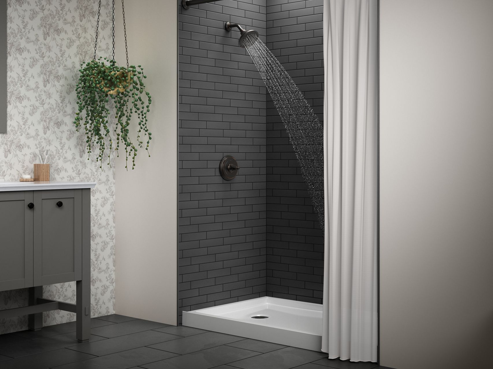 A white shower base in a shower with dark gray tile walls and matte black shower components.