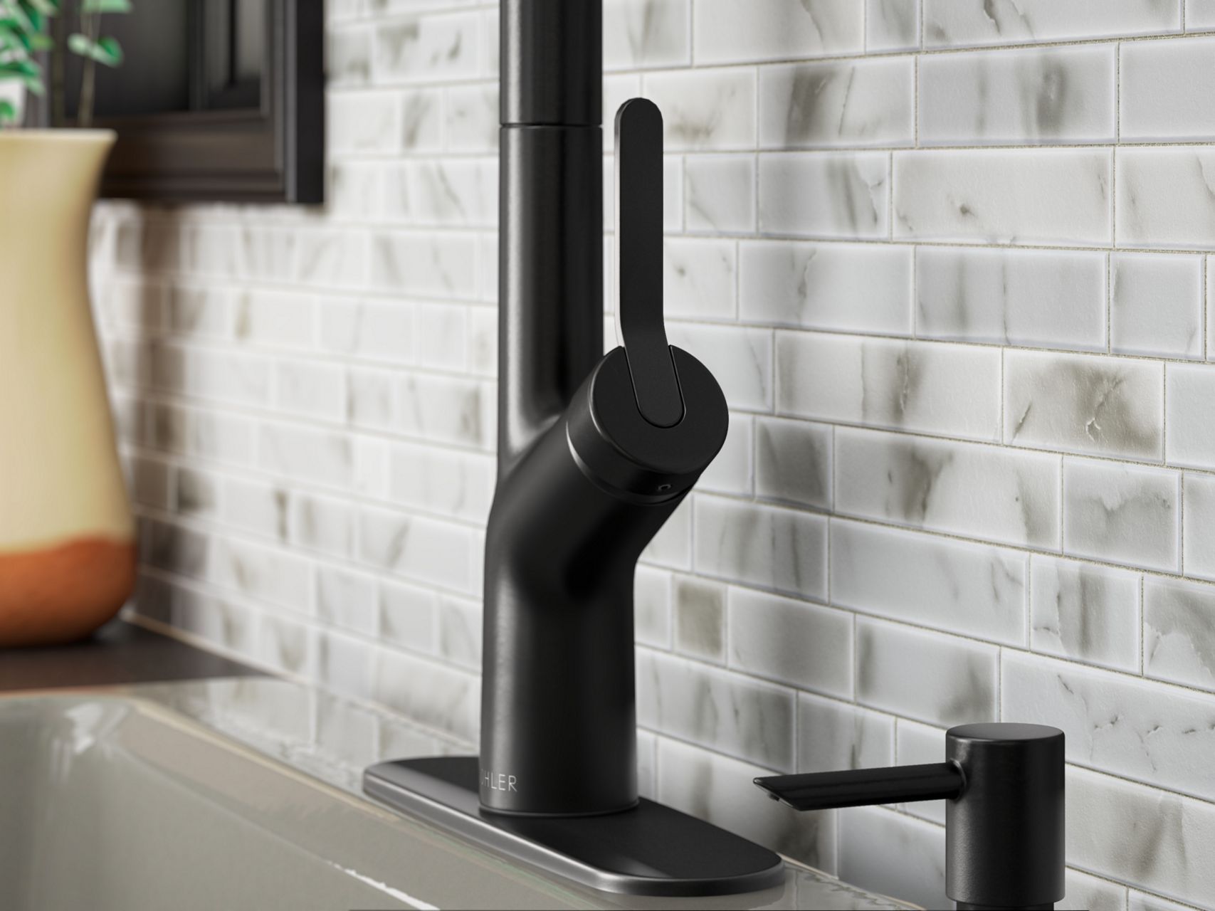 A close up shot of a matte black sink faucet with a single lever.