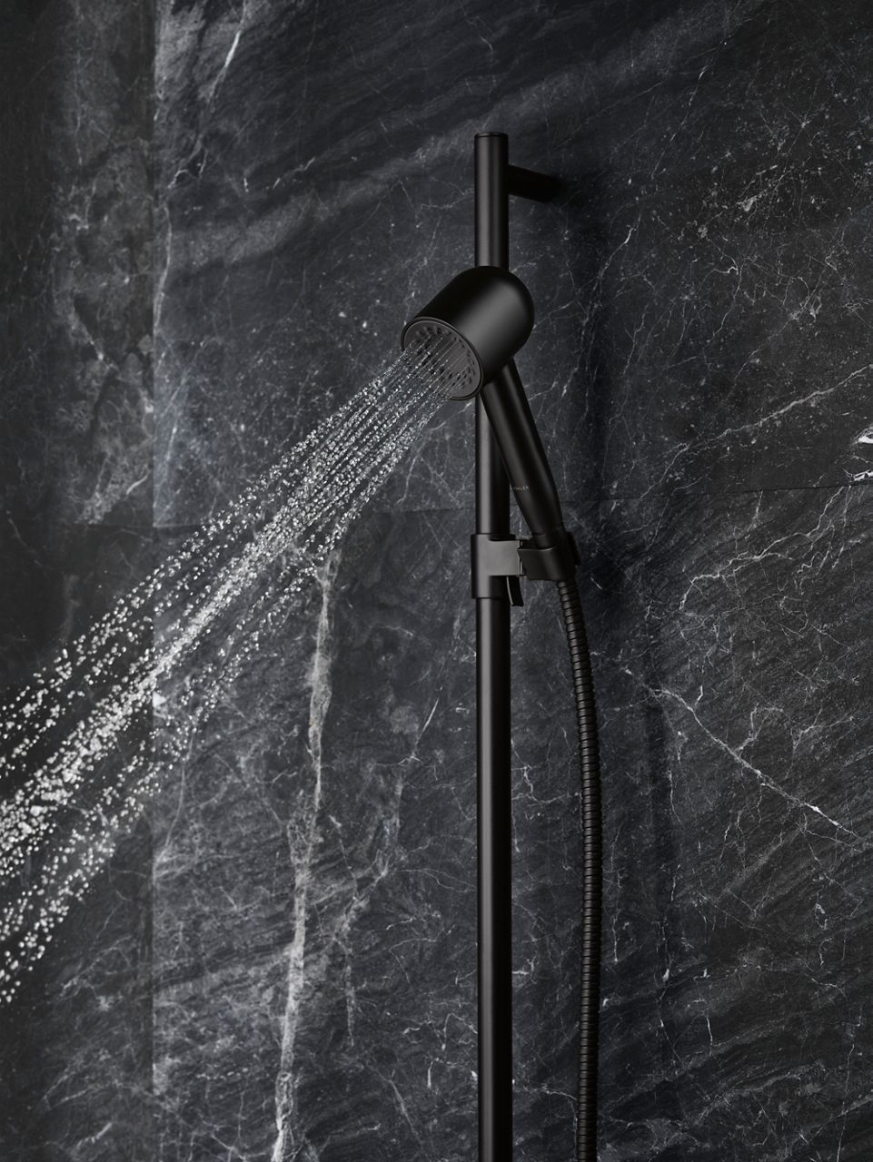 Close-up detail of a handshower with water coming out of it.