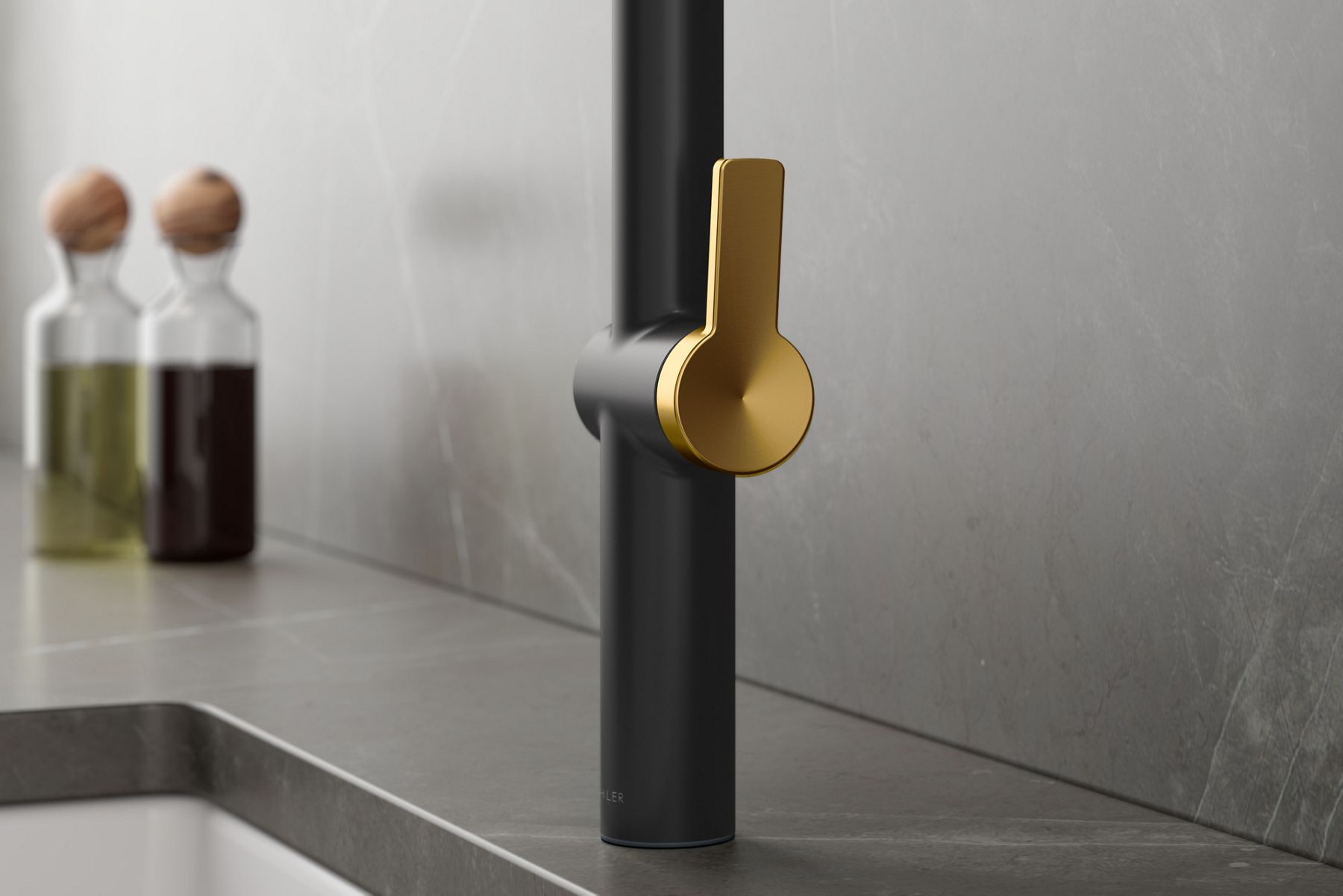 A close up shot of a black sink faucet with a gold lever.