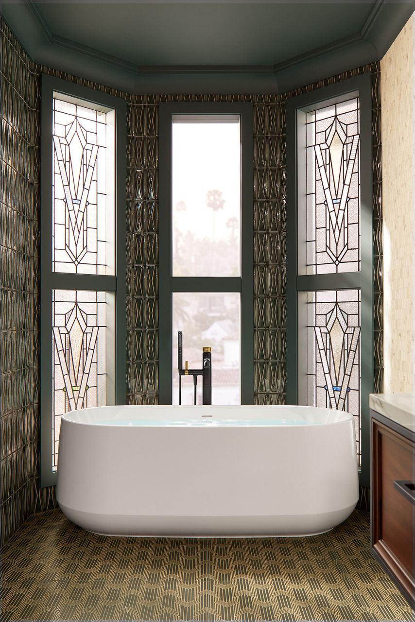 A white freestanding bath surrounded by three banks of leaded glass windows rising from floor to ceiling.