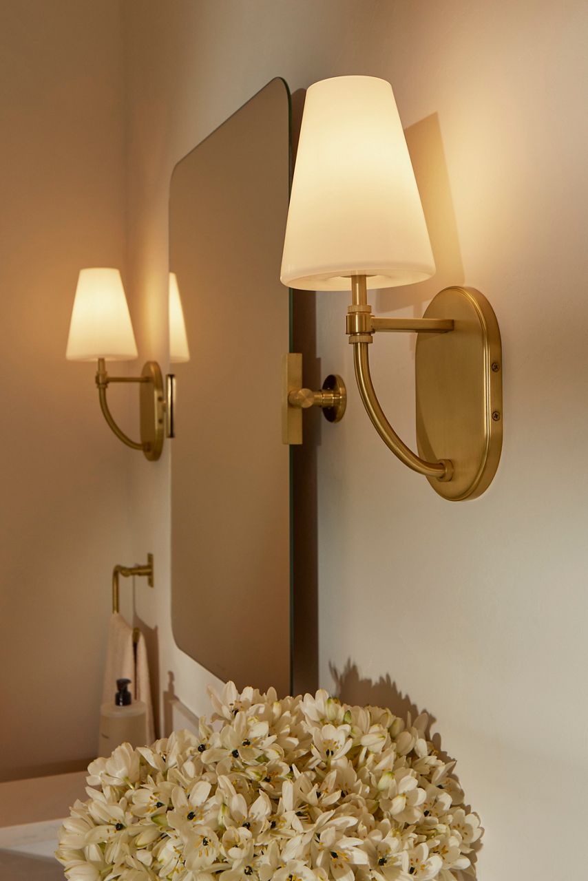 A brushed brass sconce light designed by Shea McGee.