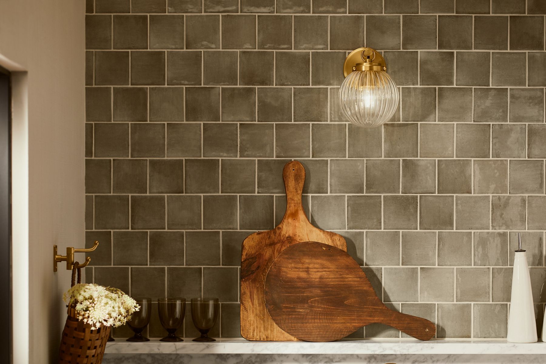 Close up of a brushed brass and globe glass sconce light designed by Shea McGee.