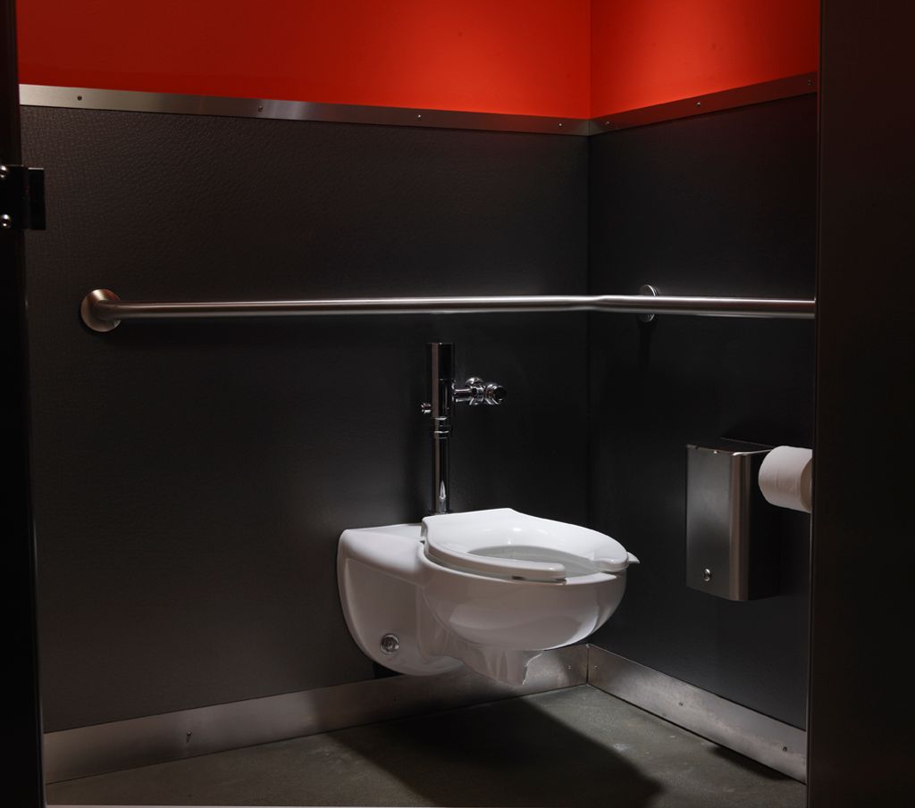 A wall-mount public toilet against a dark wall.