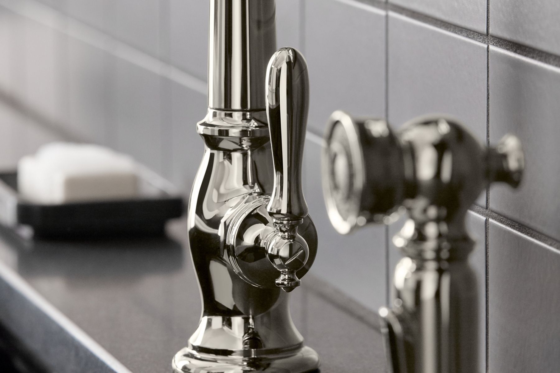 A close up shot of a silver nickel sink faucet with a single lever.
