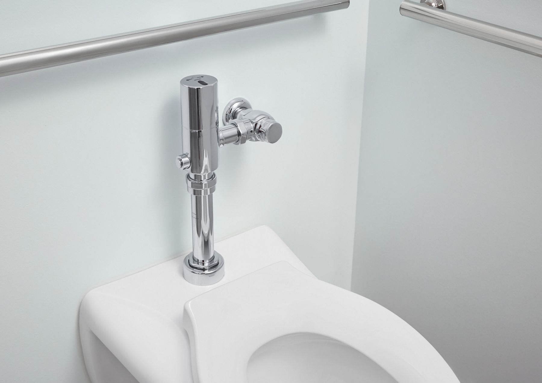 Close up of a chrome flushometer.
