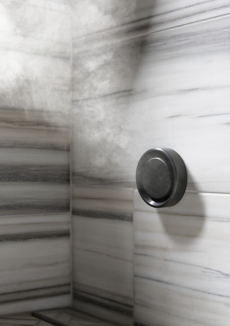 Steam emitting from a steam system attached to a white tile wall gray horizontal lines.