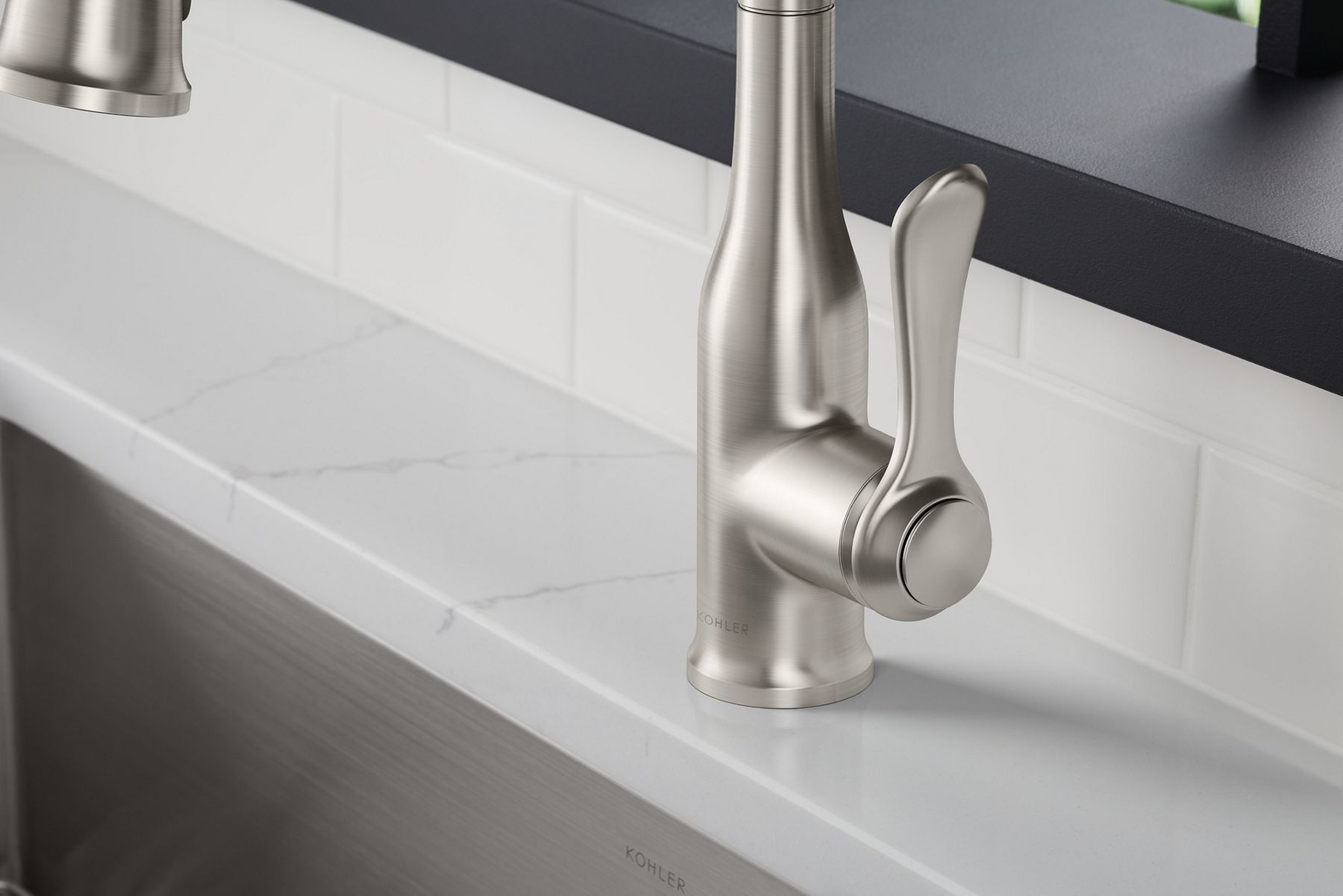 A close up shot of a stainless steel silver sink faucet with a single lever.