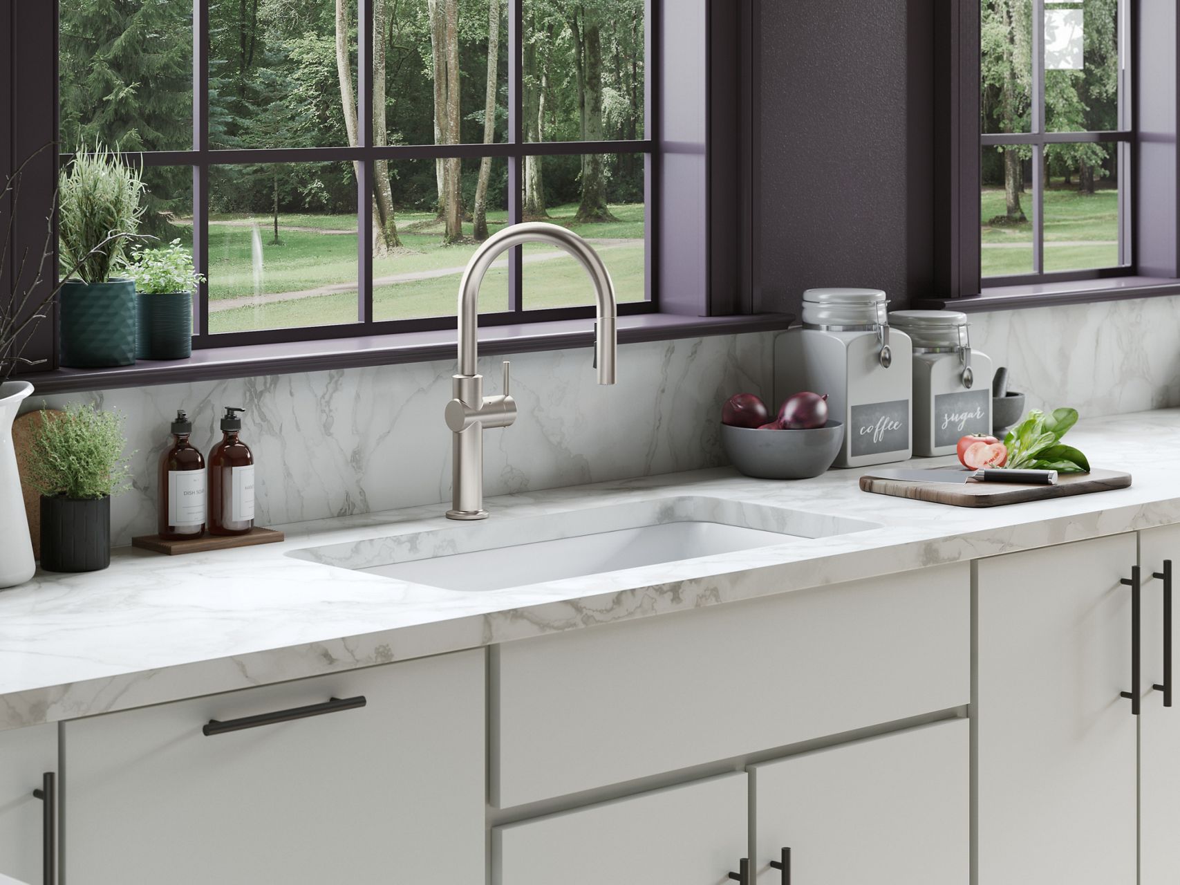 A sleek, stainless steel kitchen faucet with a high-arched design over a white sink, set against a bright marble backsplash and a window view.