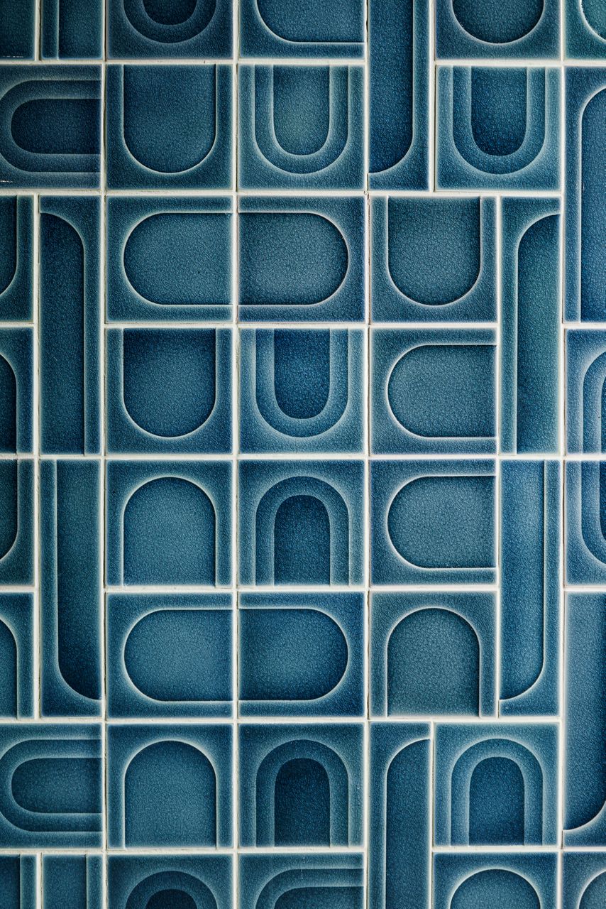 Blue geometric tile with circular and rectangular patterns, designed for decorative wall or floor use.
