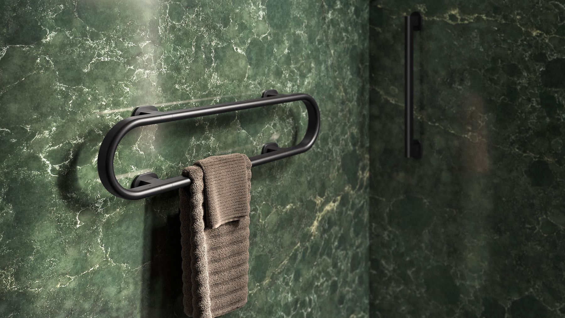 Close-up of a modern black grab bar attached to a dark green marble wall.