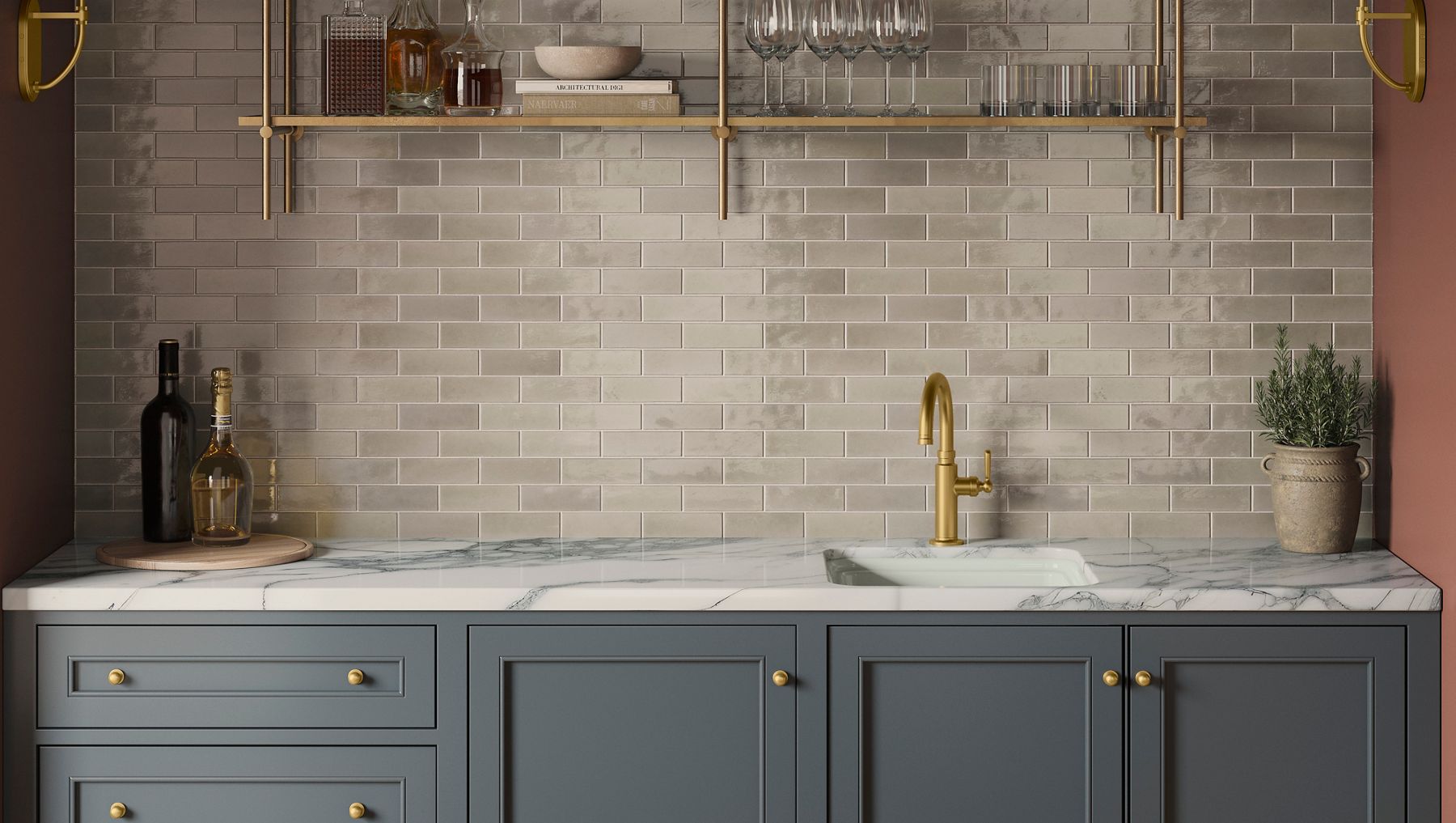 The Audrine bar sink in a clean and modern space featuring grey cabinets, gold finishes, and marble countertops.