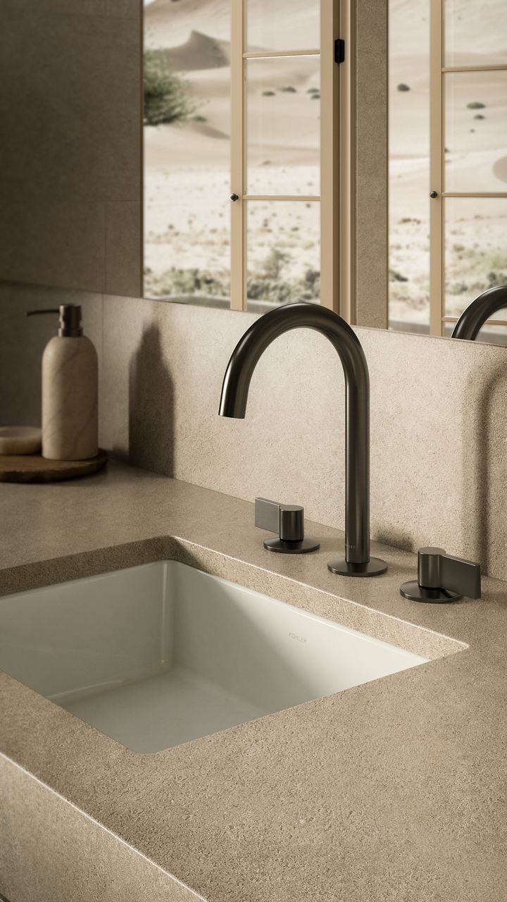 Bathroom countertop with matte black faucets and integrated sink in a minimalist style.