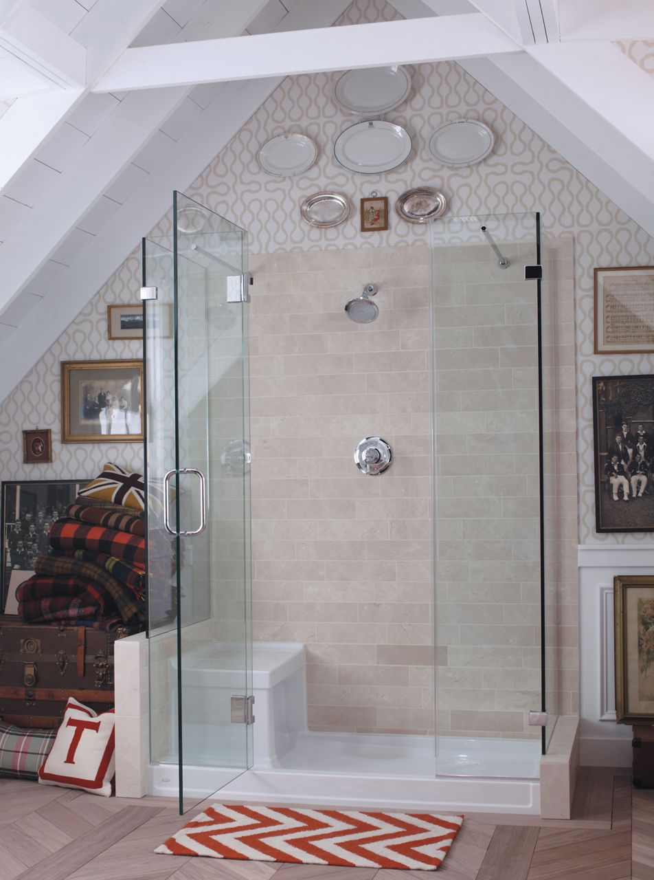 A walk-in shower in an attic bathroom with glass shower panels and door, tan tile back wall, and white KOHLER Tresham shower base.