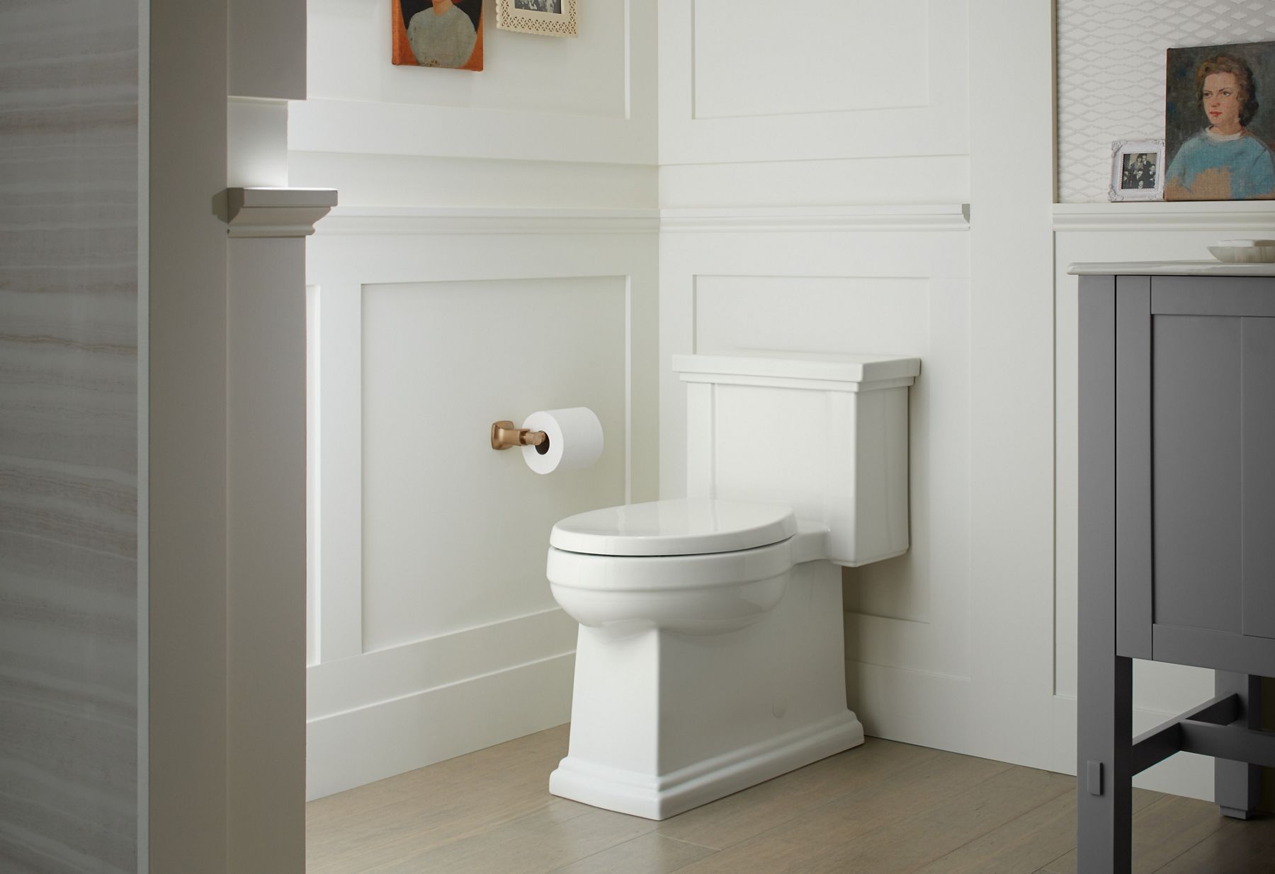 A white KOHLER elongated Tresham toilet in a bathroom with white board and batten walls.