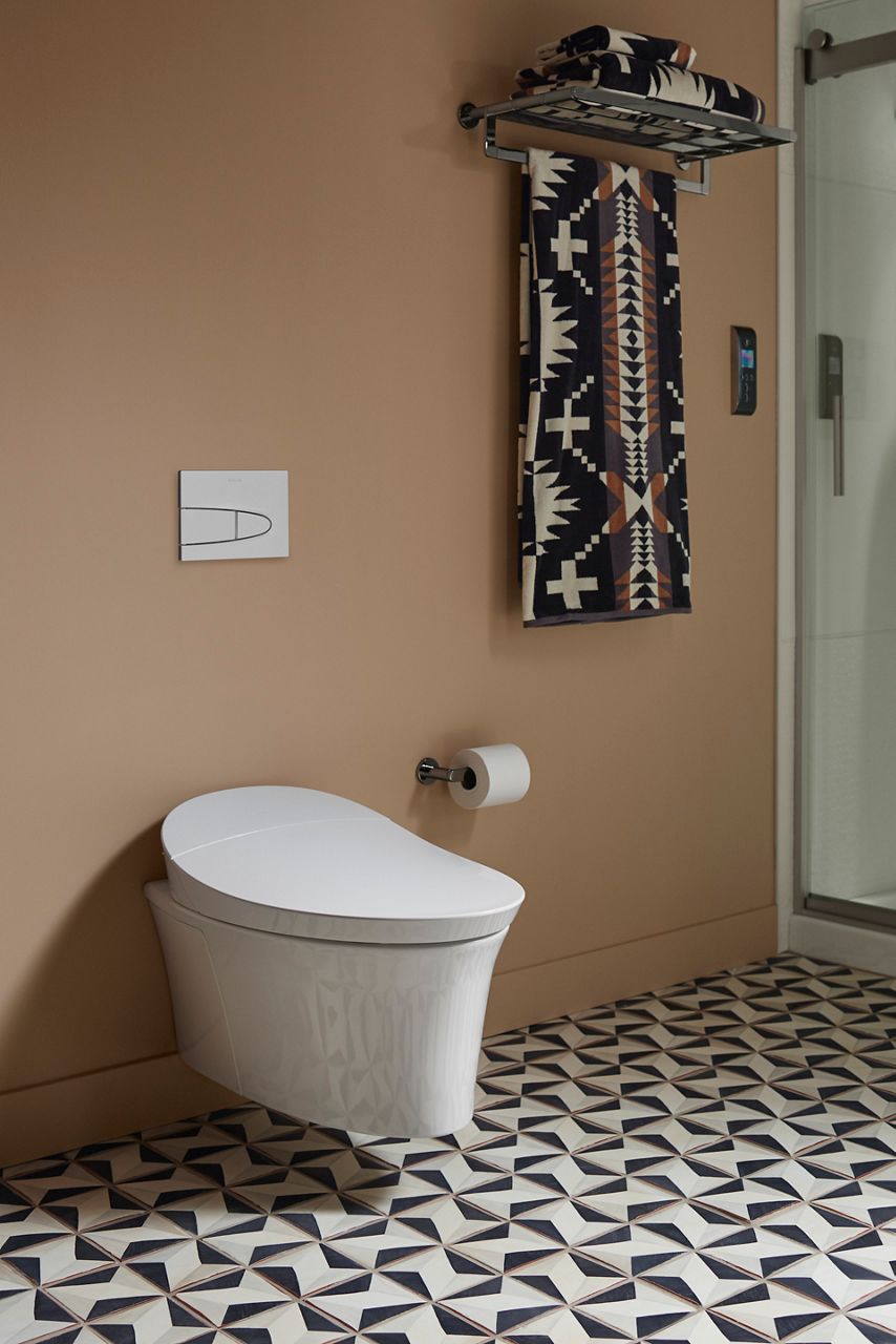 Wall-hung white toilet mounted above patterned tile floor.