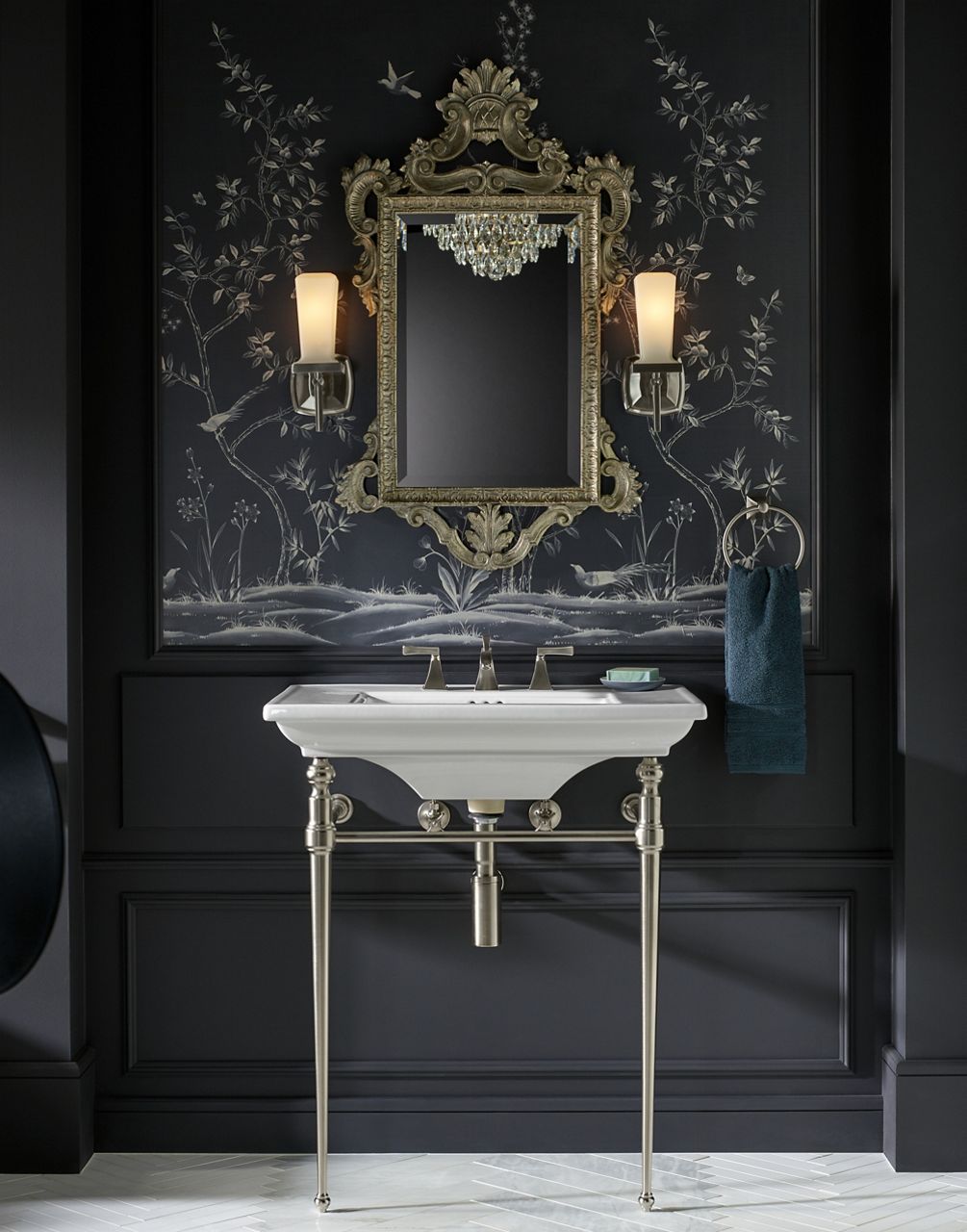 An ornately framed mirror hangs above a white KOHLER Memoirs Stately console sink with Memoirs Stately widespread bathroom faucet.