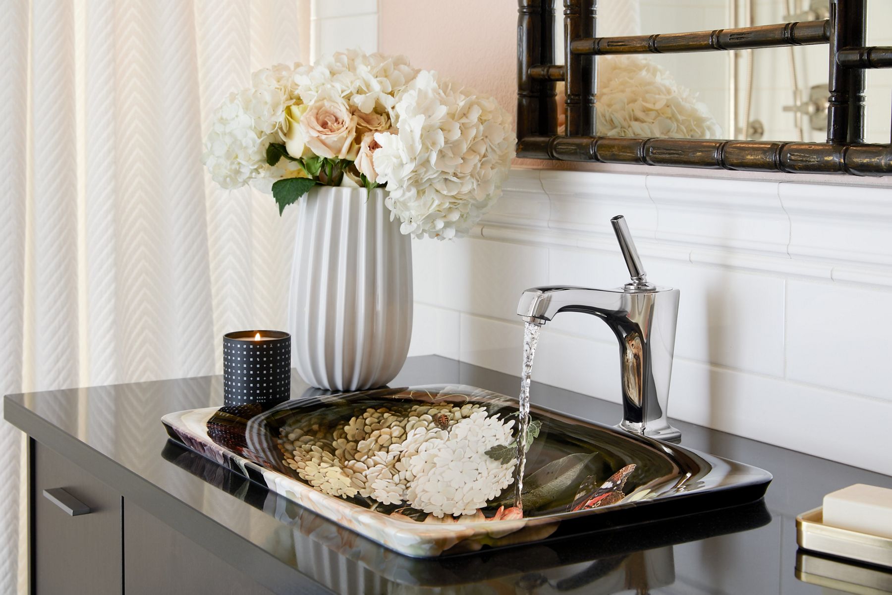 Angled view of a Dutchmaster Floral sink, showing its interior life-like print of white and pink flowers with identical flowers on the counter beside it.