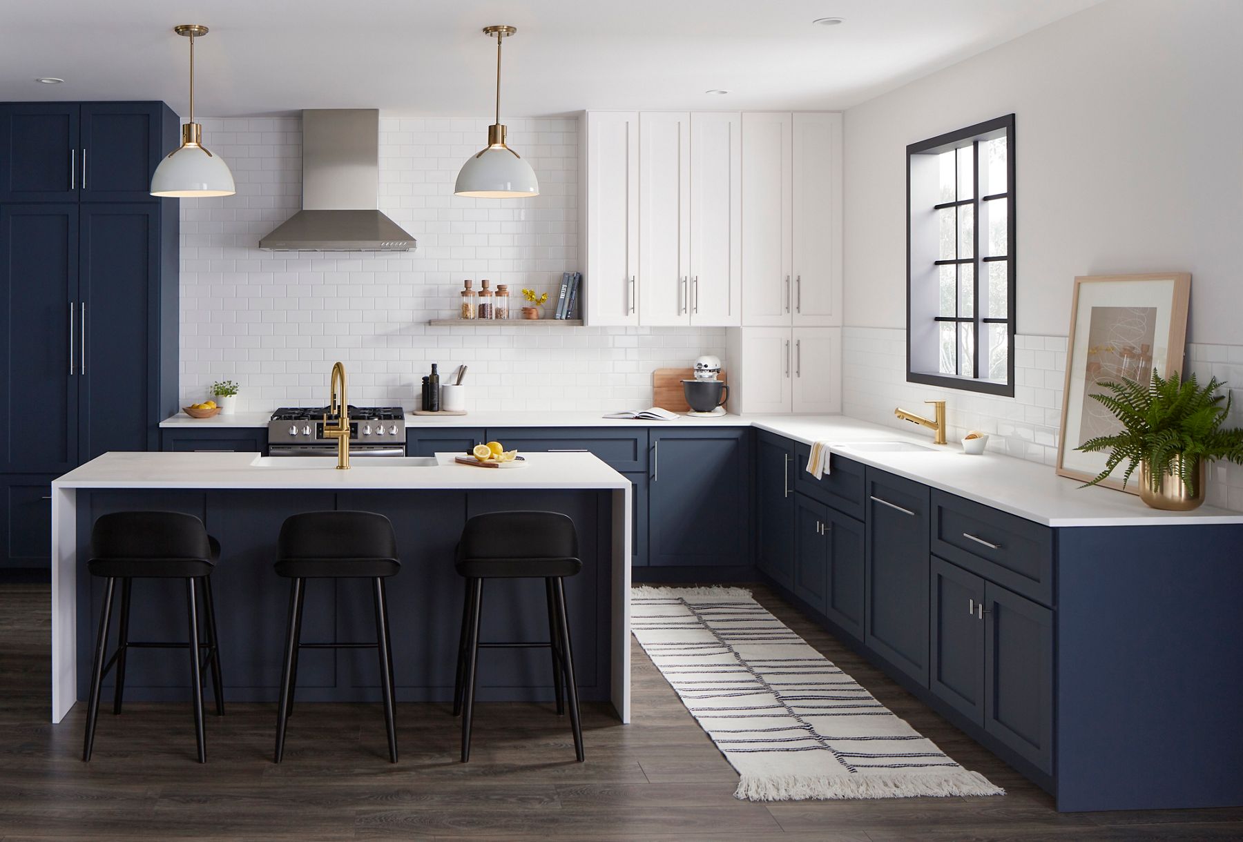 Modern kitchen with white cabinetry, navy blue lower cabinets, and a large island.