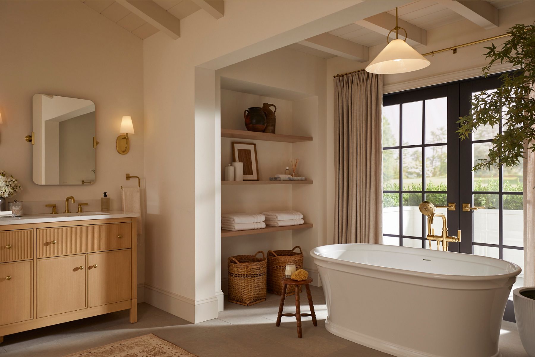 A light and bright bathroom featuring a vanity, mirrors and faucet designed by Shea McGee.