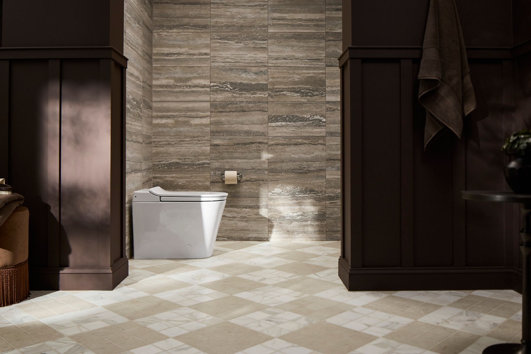 Smart toilet installed in a modern bathroom with tiled floor and dark wood cabinetry.