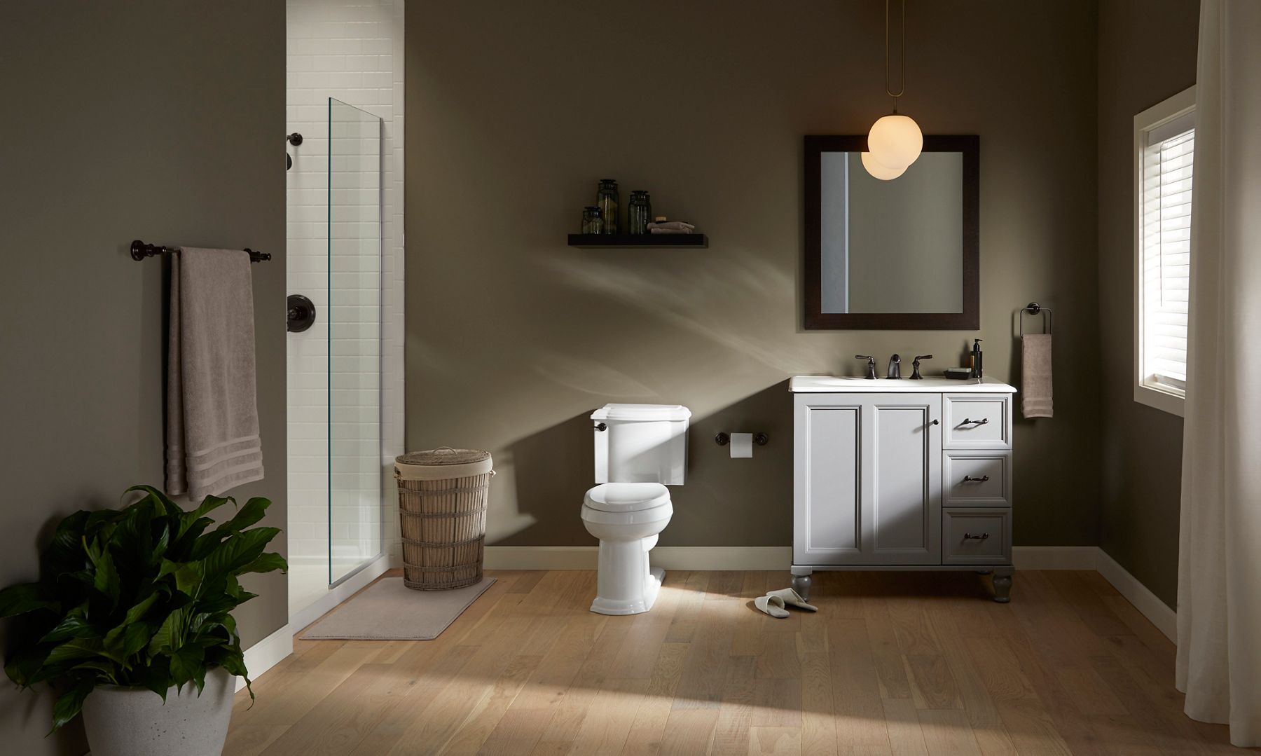 A bathroom in deep neutral tan and grays featuring Devonshire collection products.