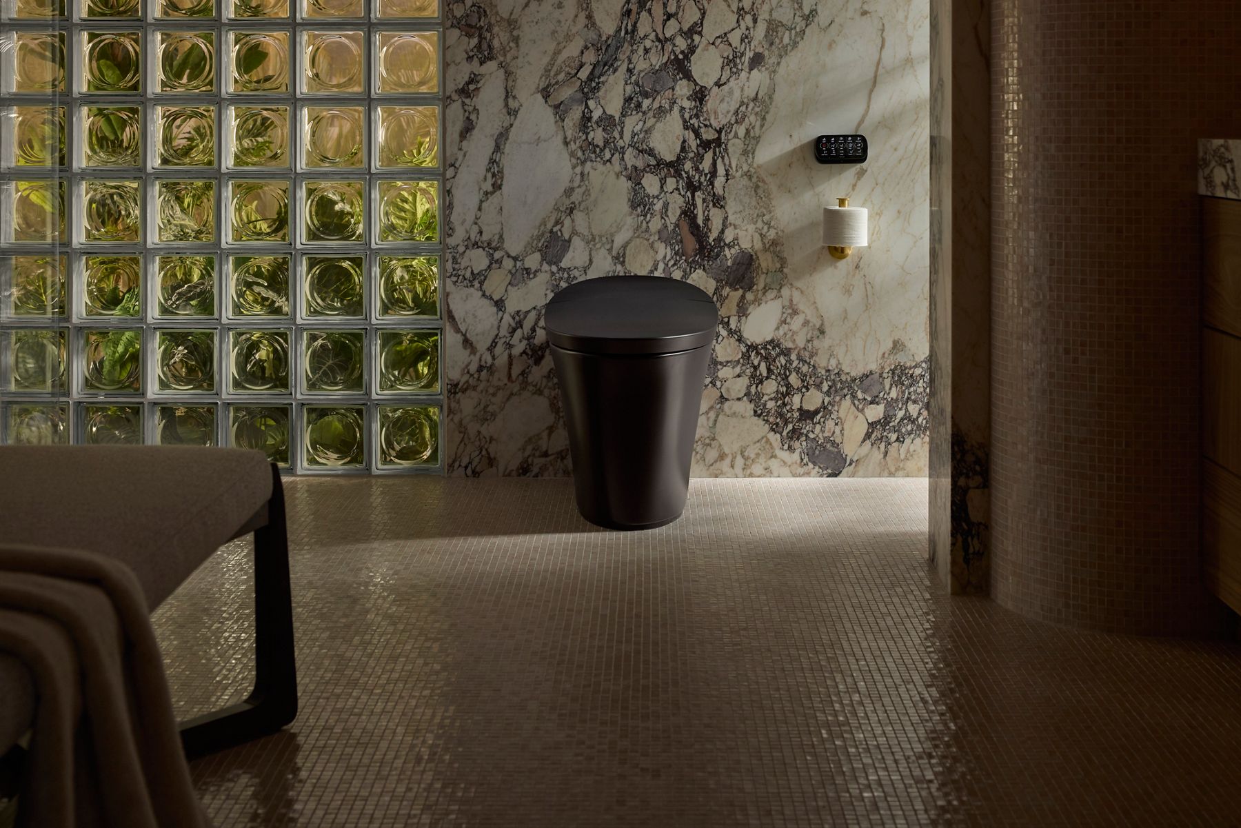 A black Veil collection smart toilet installed in a modern bathroom with a marble wall and toilet paper holder.