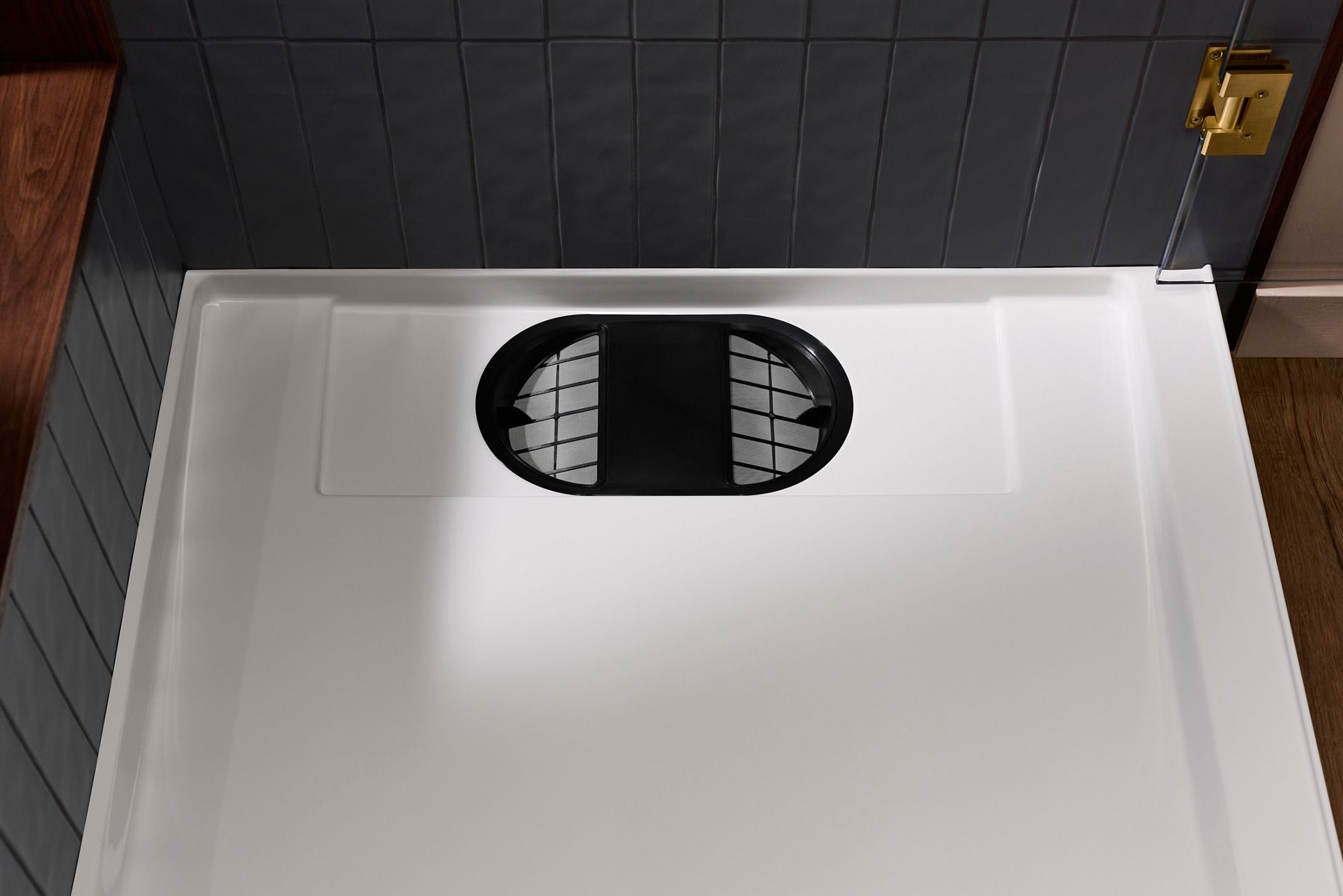 Close-up of the Kohler Anthem EvoCycle shower base showing the built-in filtration system integrated into the shower floor.