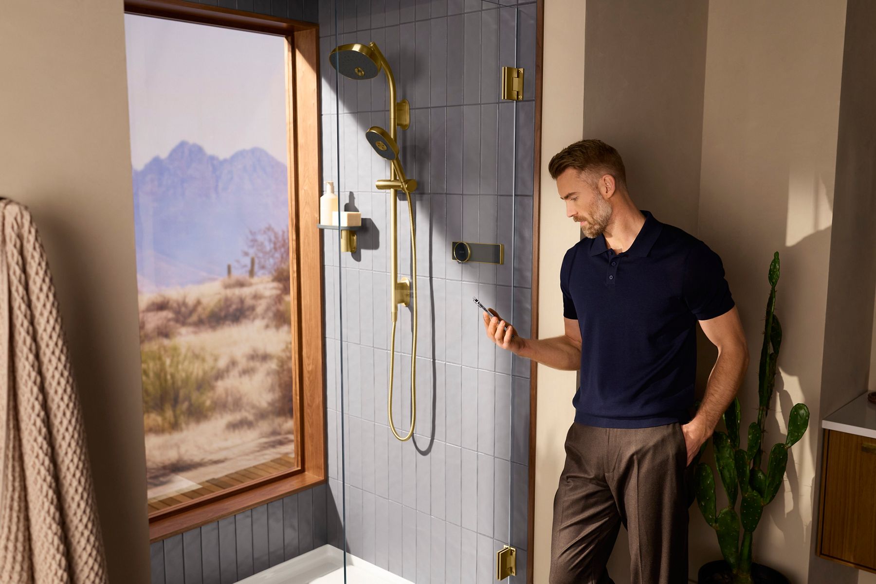Man using the Kohler Konnect app to start the Kohler Anthem EvoCycle smart shower before entering the shower.
