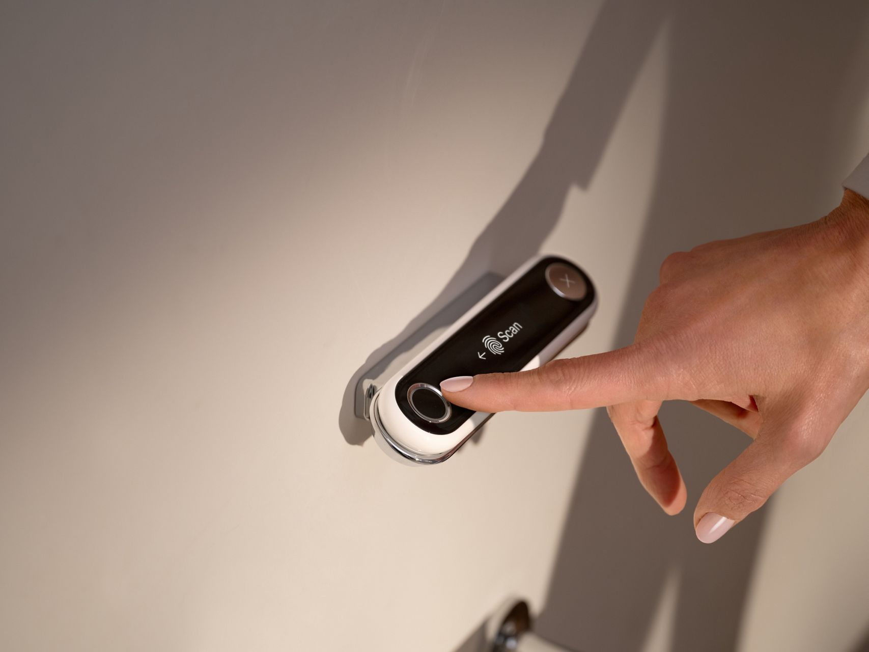 Finger authenticating with the Kohler Health fingerprint remote, providing secure, private access to Dekoda health sessions.