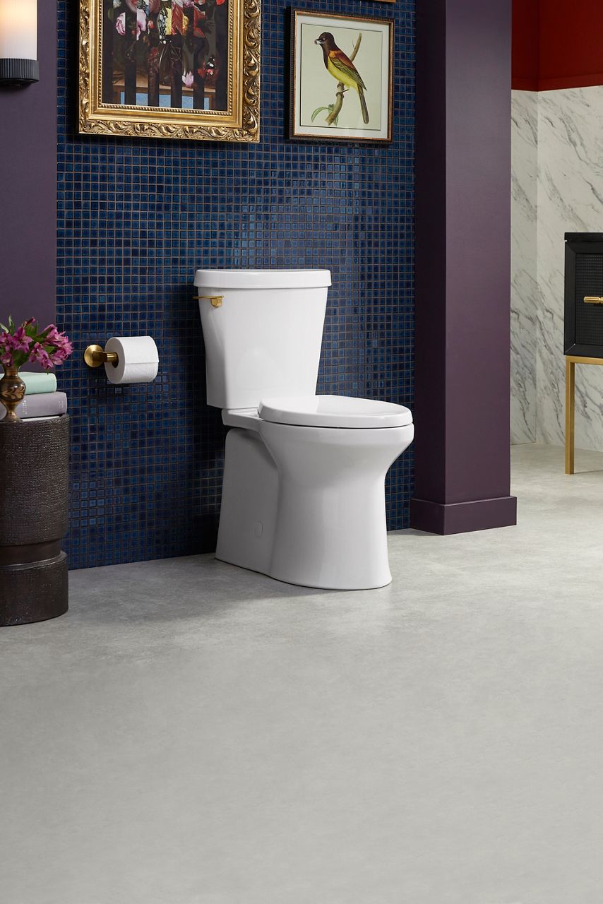 Une toilette blanche contre un mur carrelé bleu dans une salle de bain moderne avec des détails en marbre et des accents sombres.
