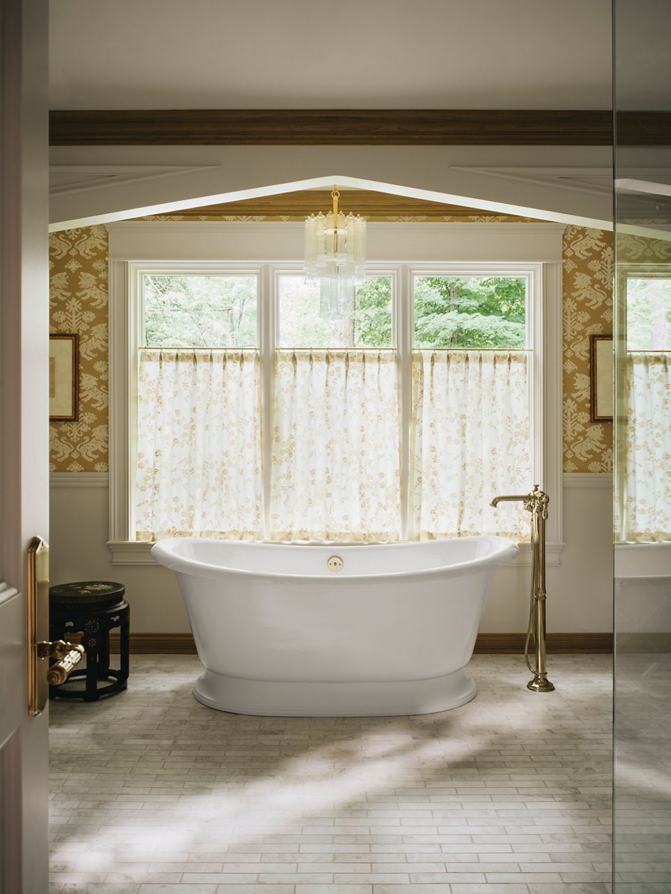 Baignoire autoportante en fonte émaillée KOHLER dans une salle de bain jaune, éclairée et accueillante.