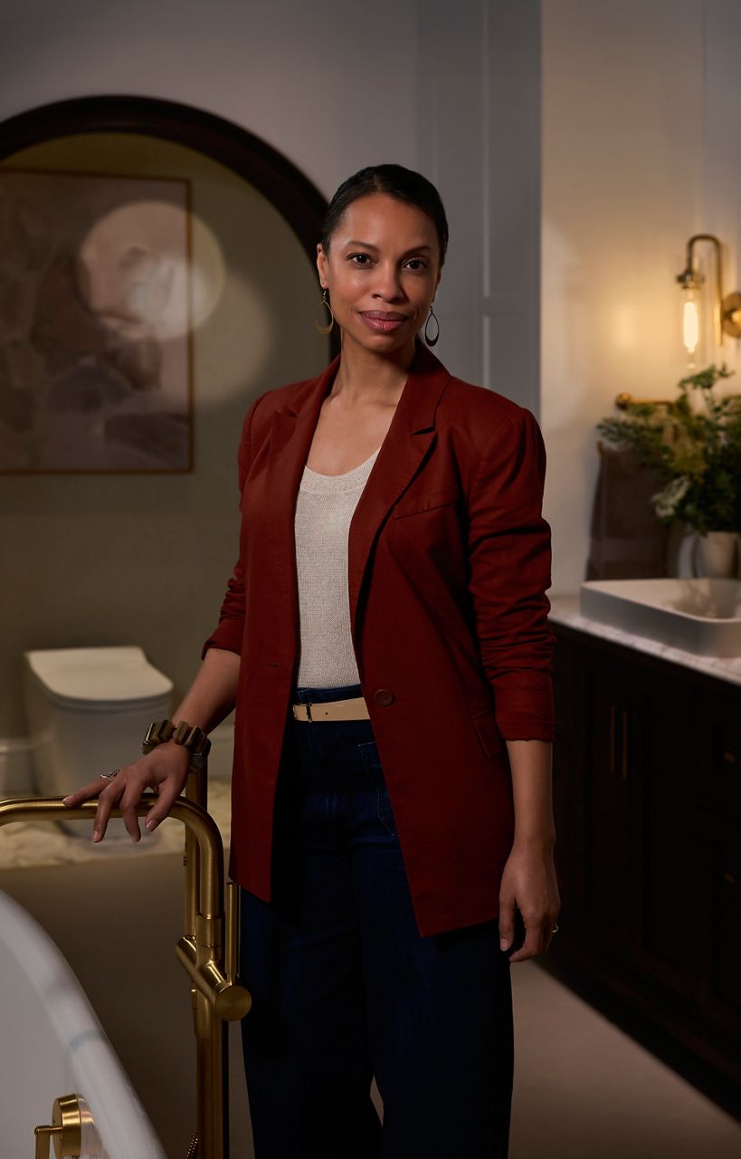 Designer Laura Hodges standing in her neutral sustainable bathroom.