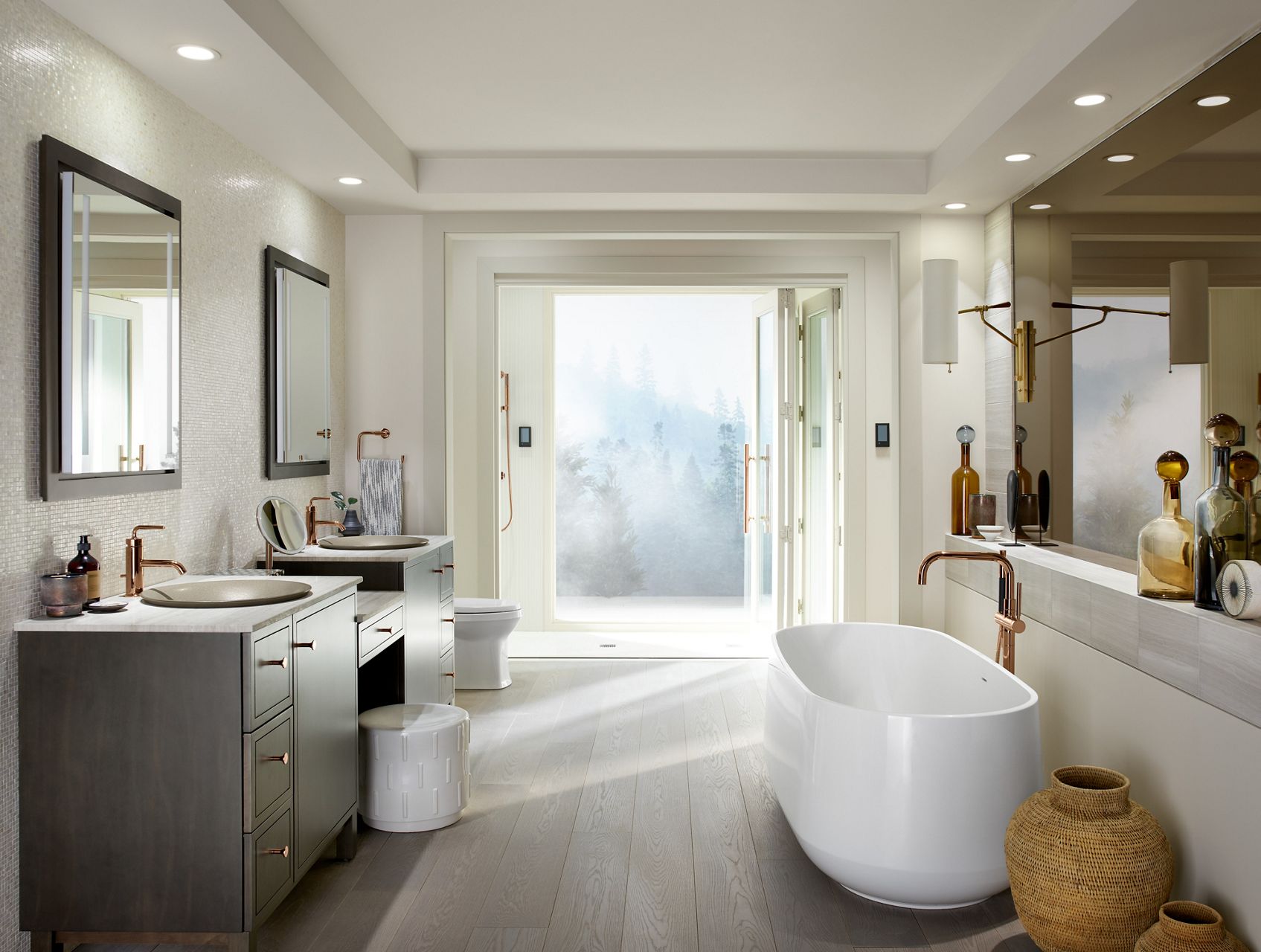 Daylight in large bathroom with Ceric freestanding bath in front of a large mirror opposite two Jacquard vanity cabinets and large shower with folding door in distance.