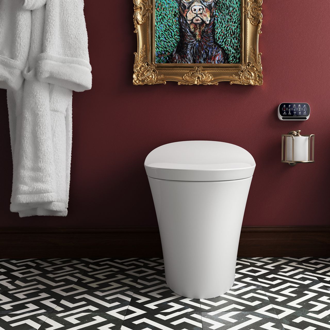A Veil intelligent toilet and wall-mount remote control in a striking bathroom with a saturated burgundy wall, a white- and black-tiled geometric patterned floor and the bottom part of an intricately detailed gold picture frame.